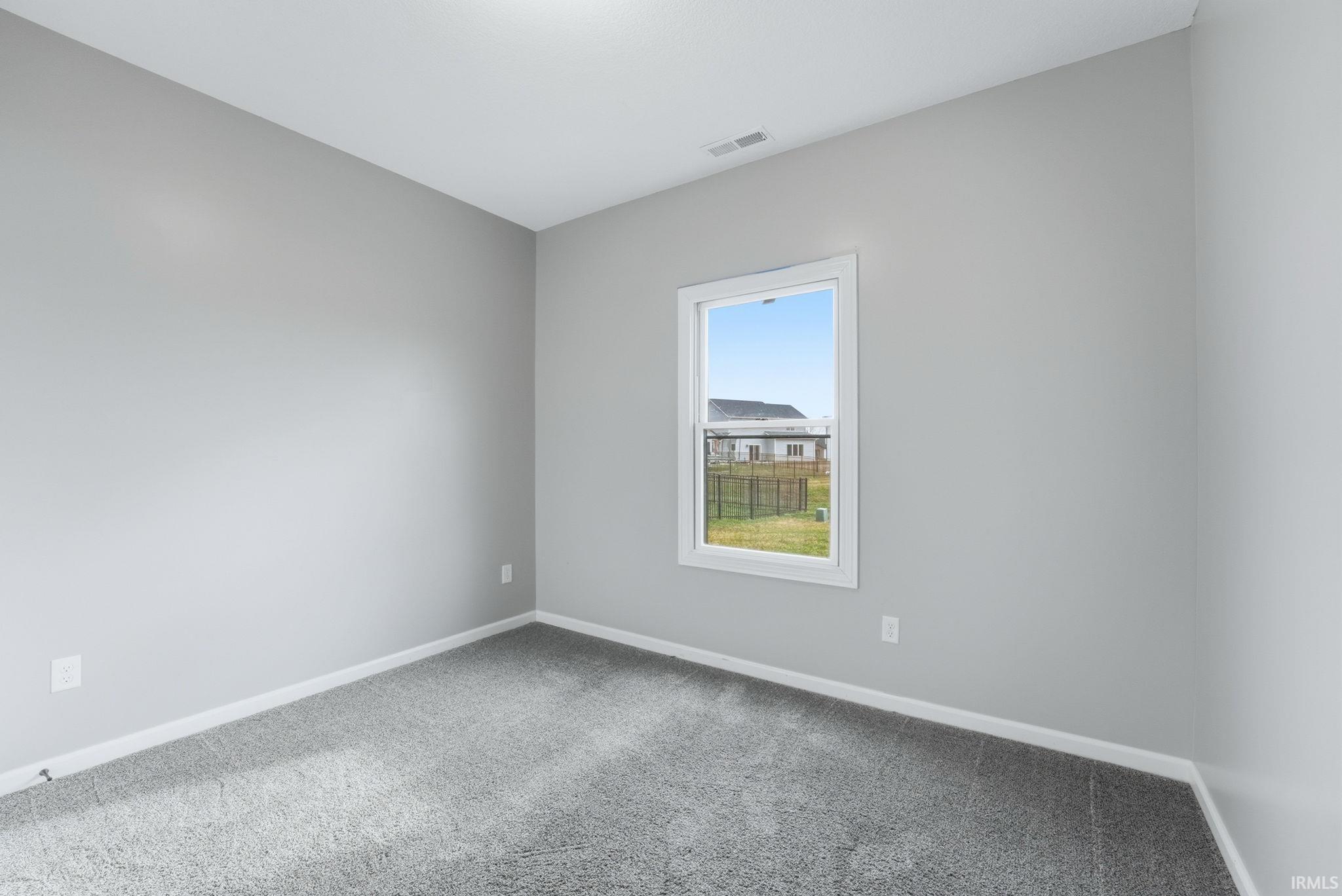 Carpeted empty room featuring baseboards