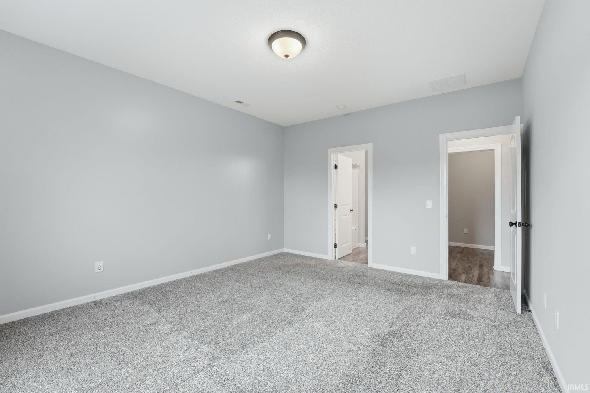 Unfurnished bedroom with baseboards and light carpet