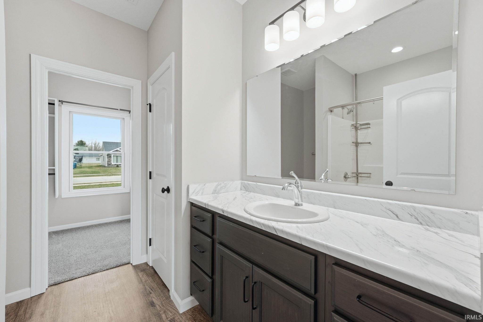 Bathroom featuring vanity, light wood-style flooring, and a shower