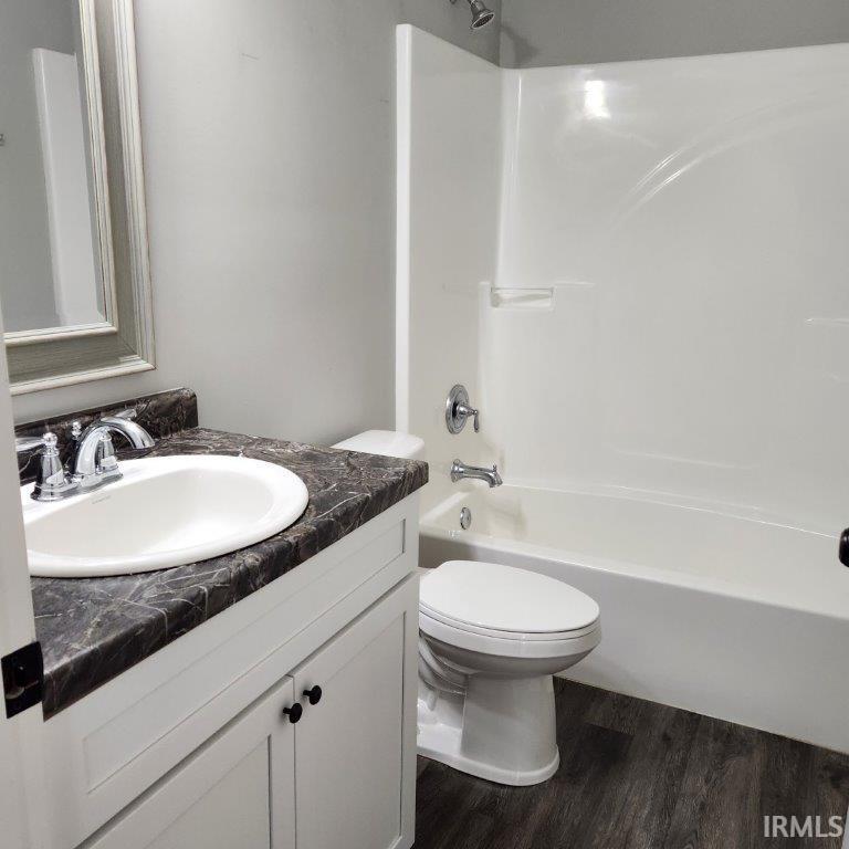 Full bathroom featuring vanity, bathtub / shower combination, and dark wood finished floors