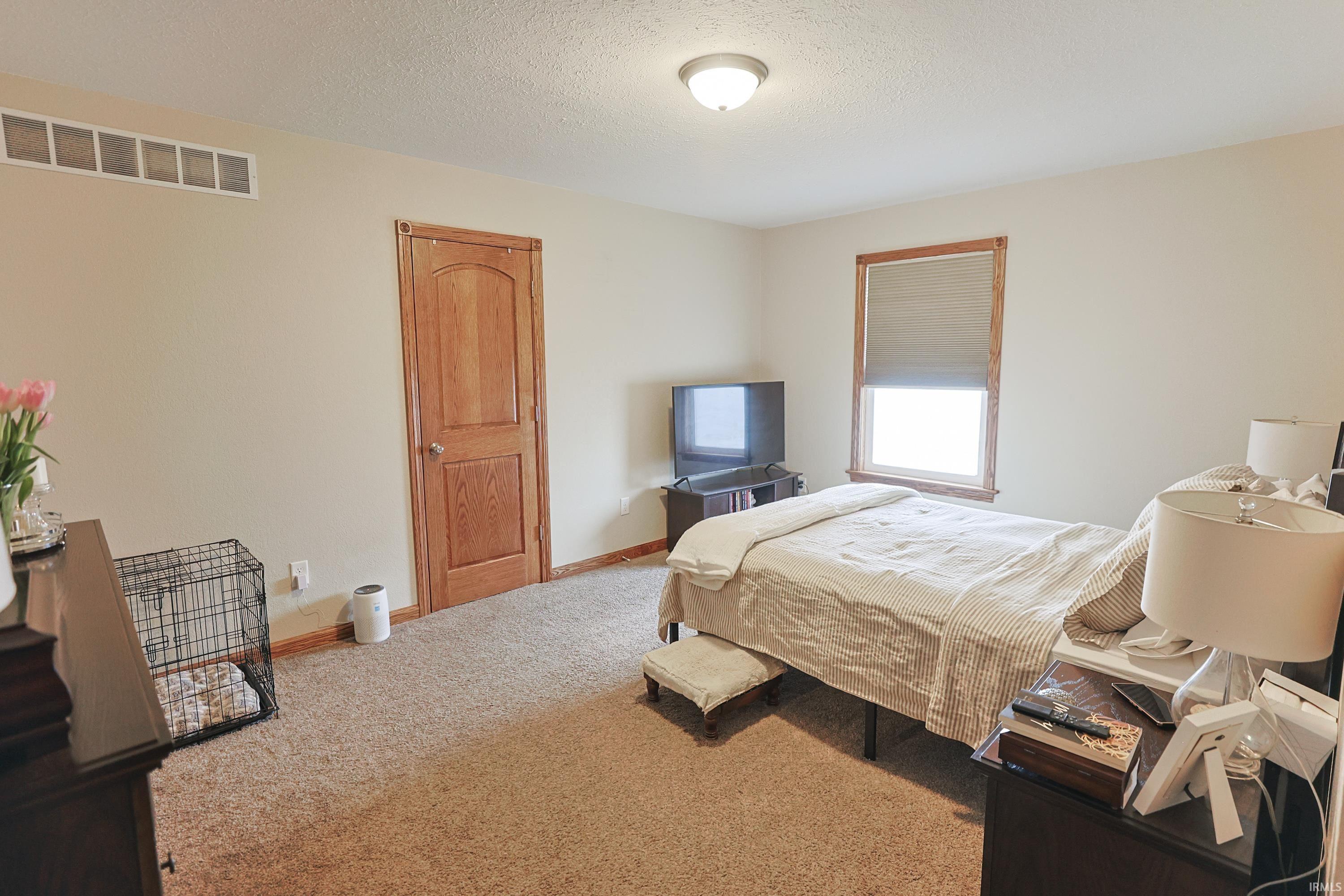 Bedroom with carpet floors and a textured ceiling