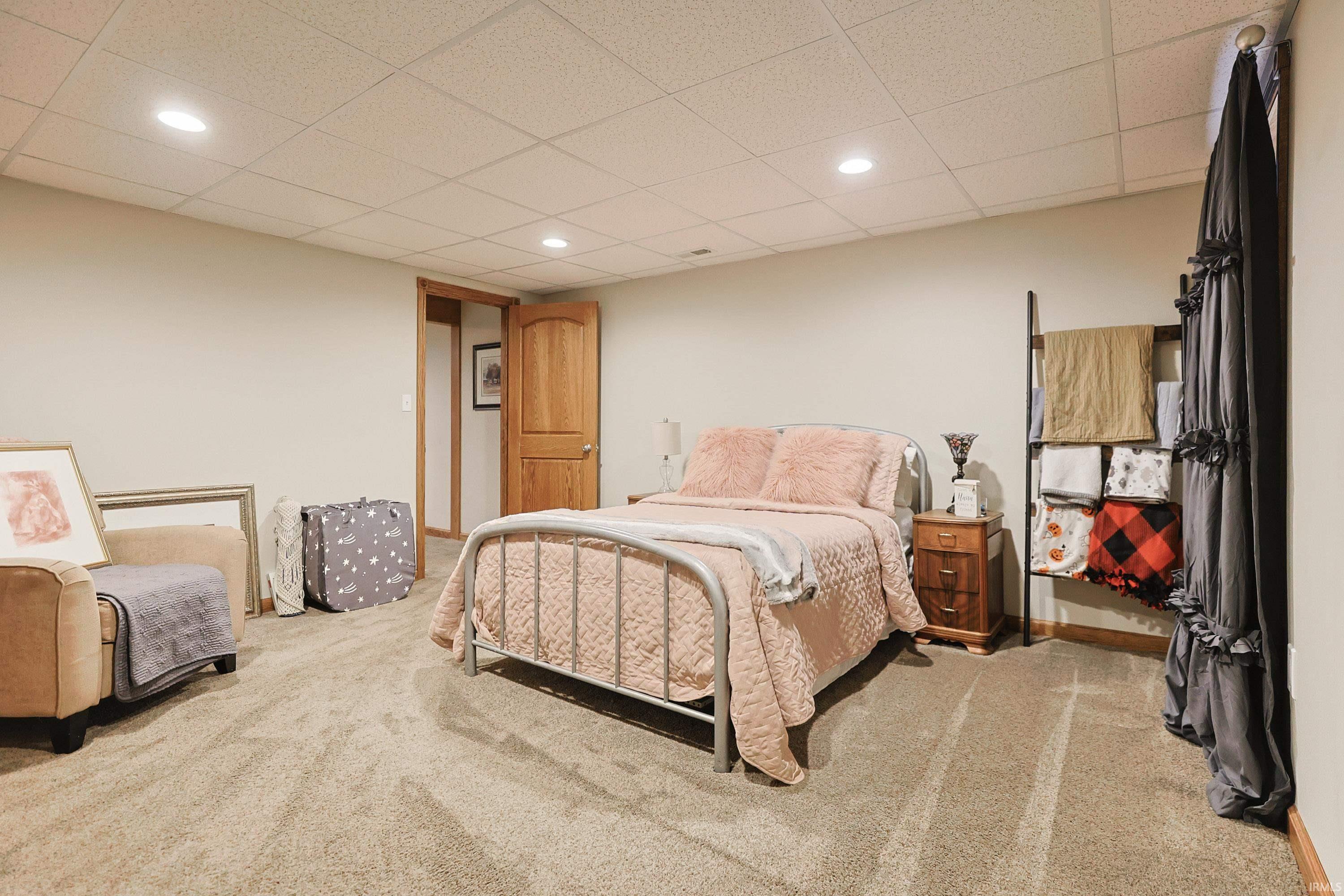 Bedroom featuring light colored carpet, a drop ceiling, and recessed lighting