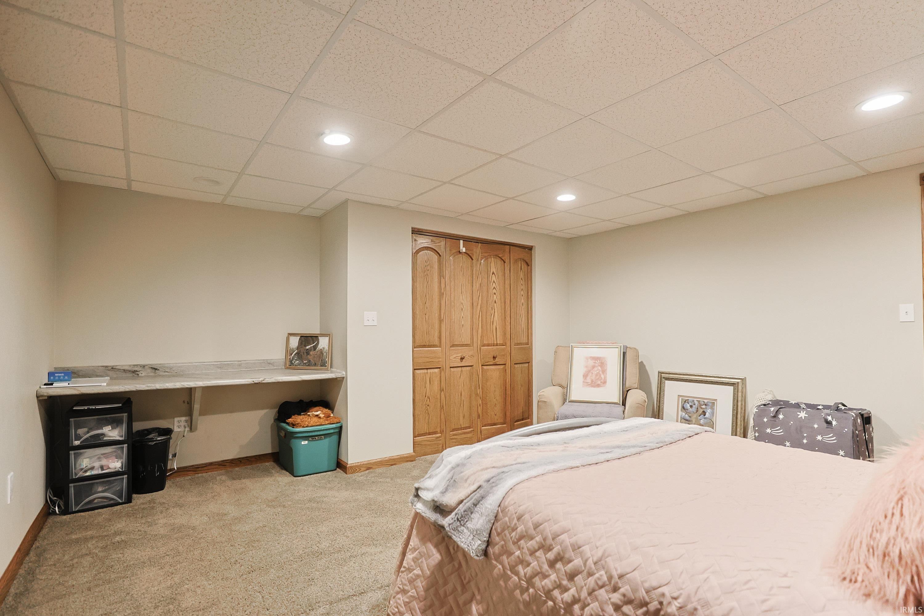 Bedroom featuring a drop ceiling, light colored carpet, a closet, and recessed lighting