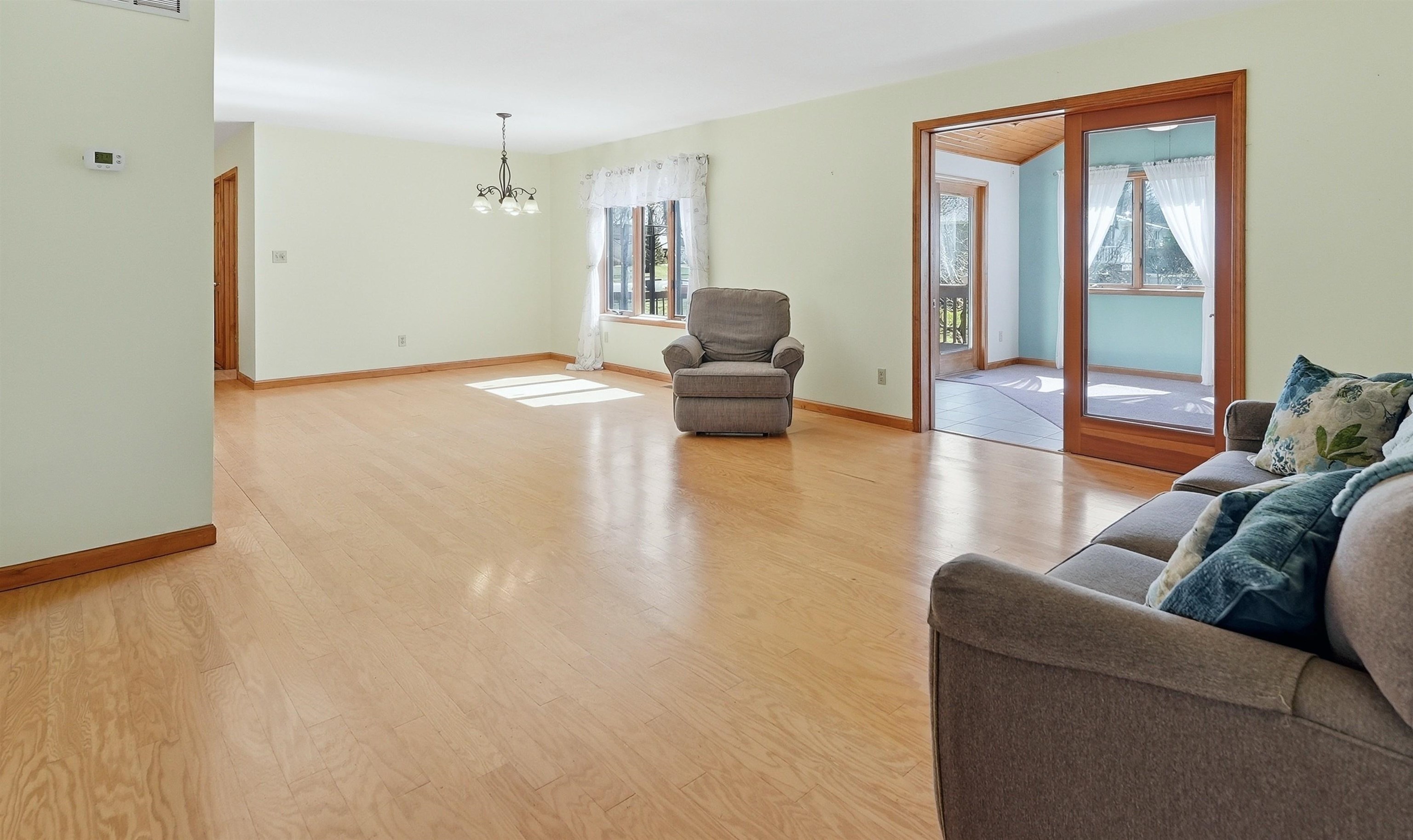 The great room area features a fully equipped kitchen, dining area, living room with a sunroom, double doors, and