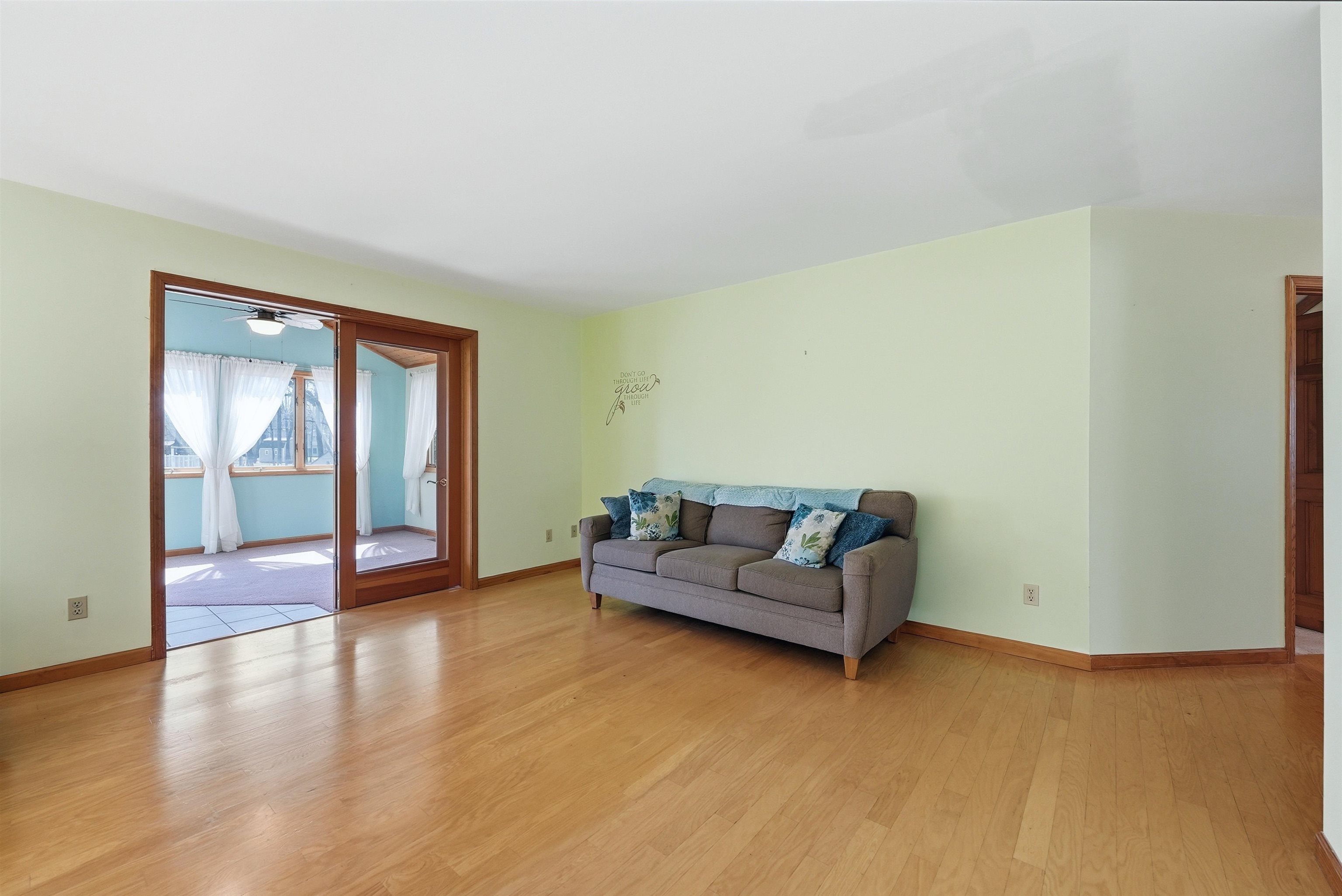 Living room with light wood-style flooring and a ceiling fan