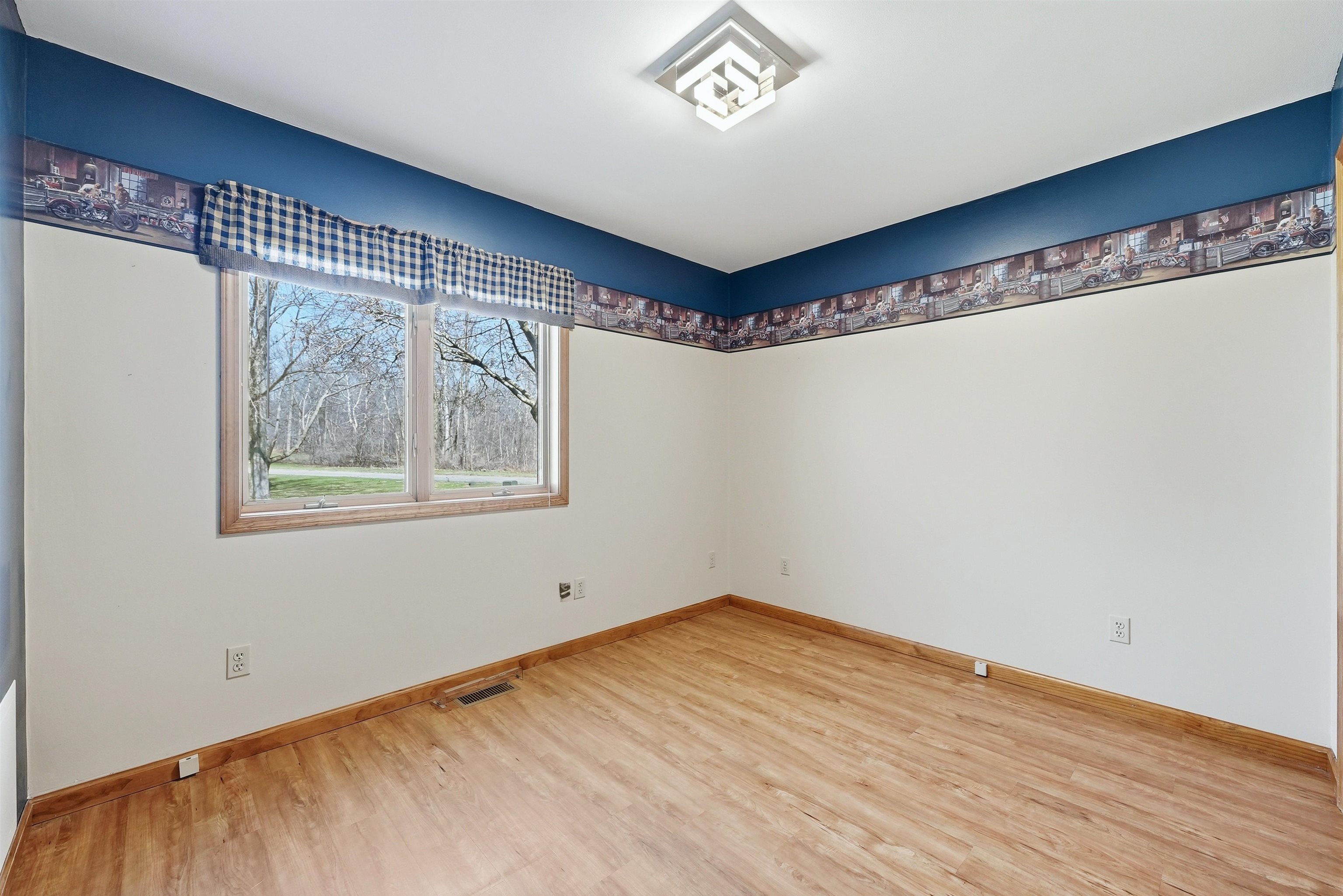 Bedroom with light wood finished floors and baseboards