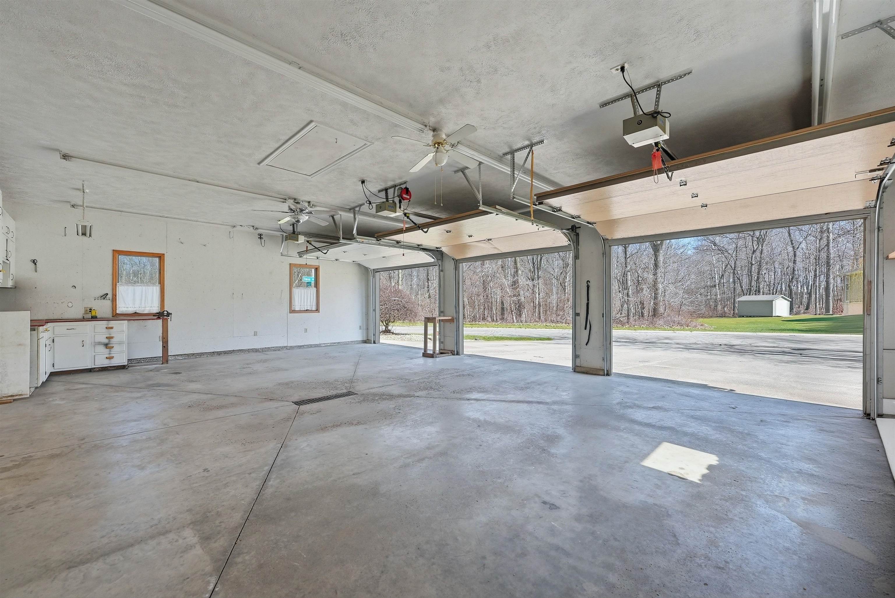 Garage featuring ceiling fan and a garage door opener