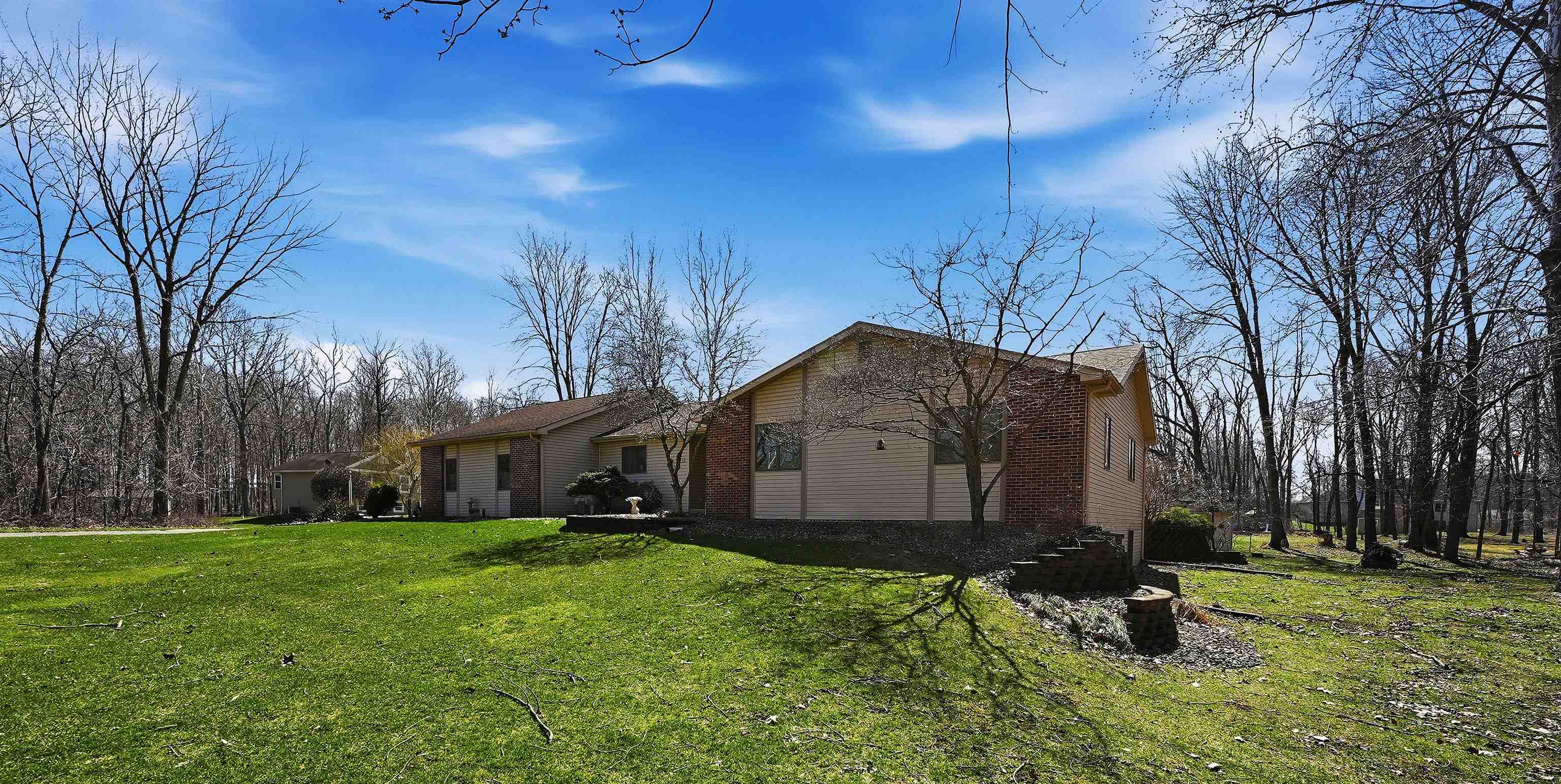 View of side of property featuring a lawn and brick siding