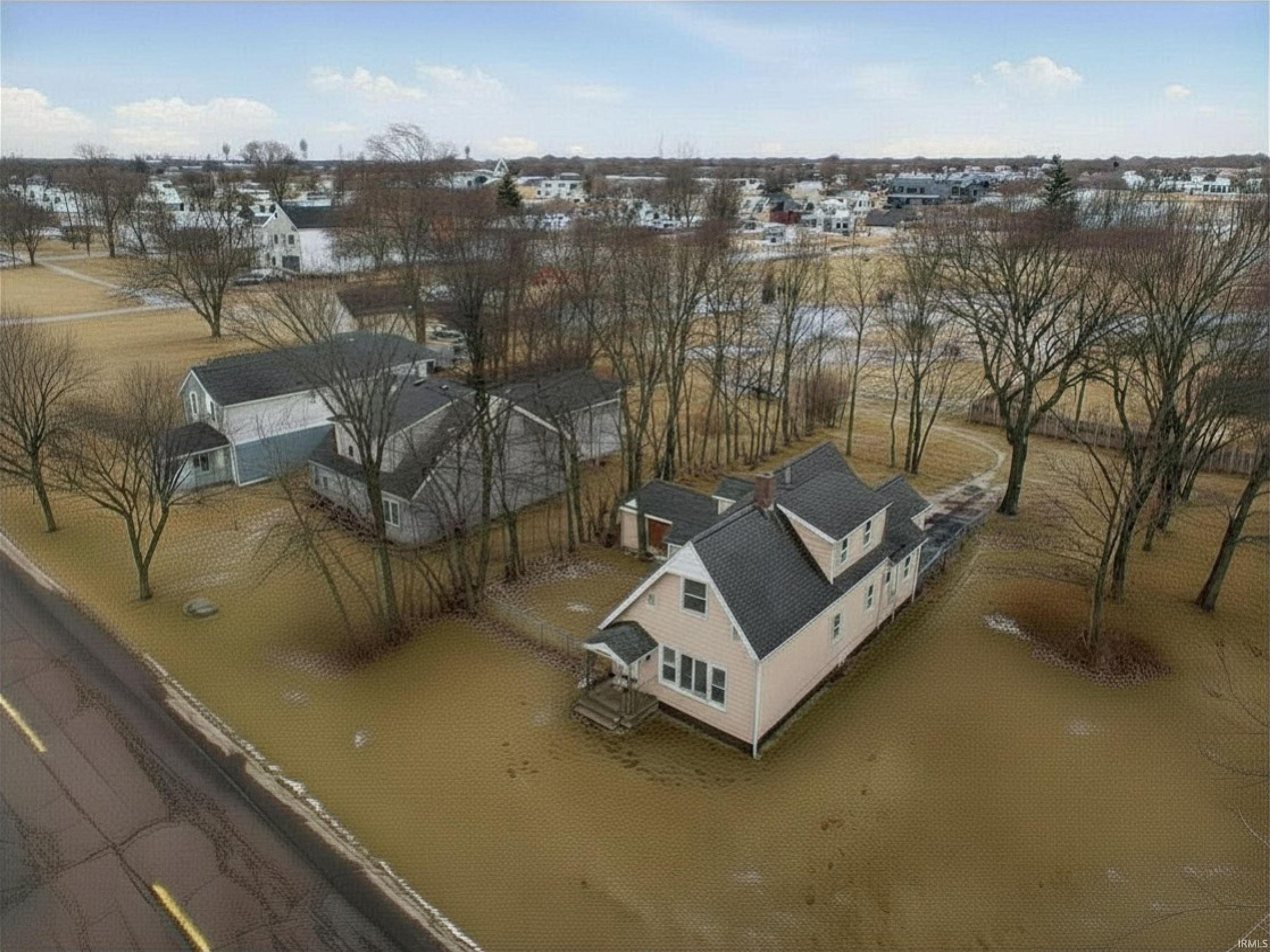 Two-story residence featuring light-colored siding, a dark shingled roof, and a covered front porch