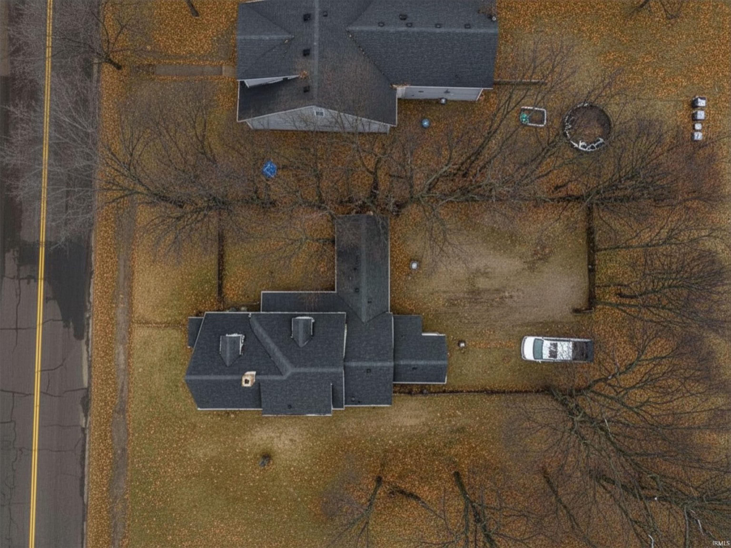 Property featuring a dark shingle roof and a green-brown lawn