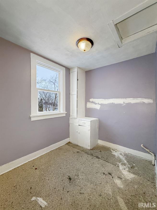 Empty room with baseboards and a textured ceiling