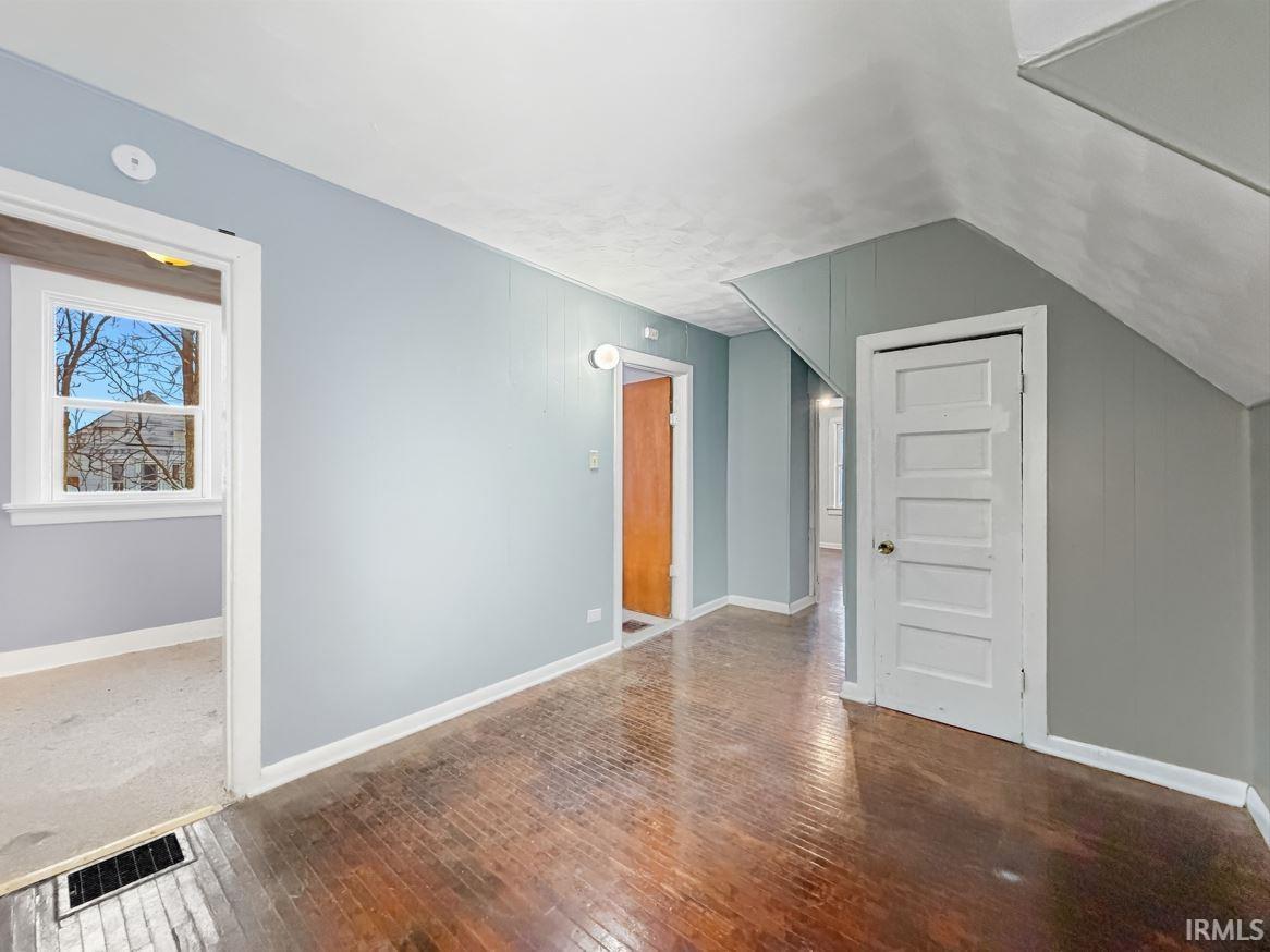 Bonus room featuring wood-type flooring and vaulted ceiling