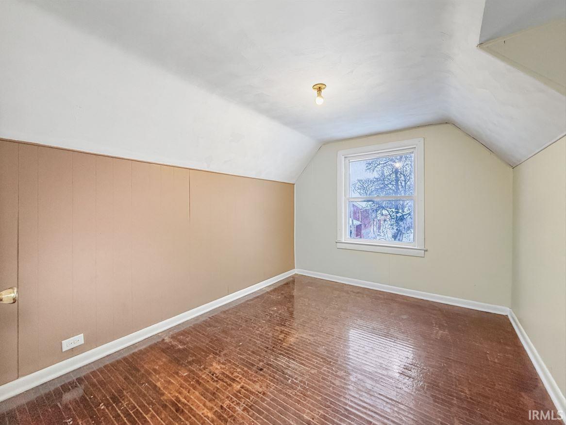 Bonus room featuring dark wood finished floors and baseboards