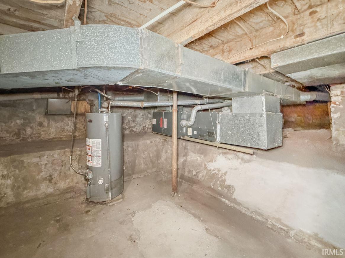 Unfinished below grade area featuring water heater