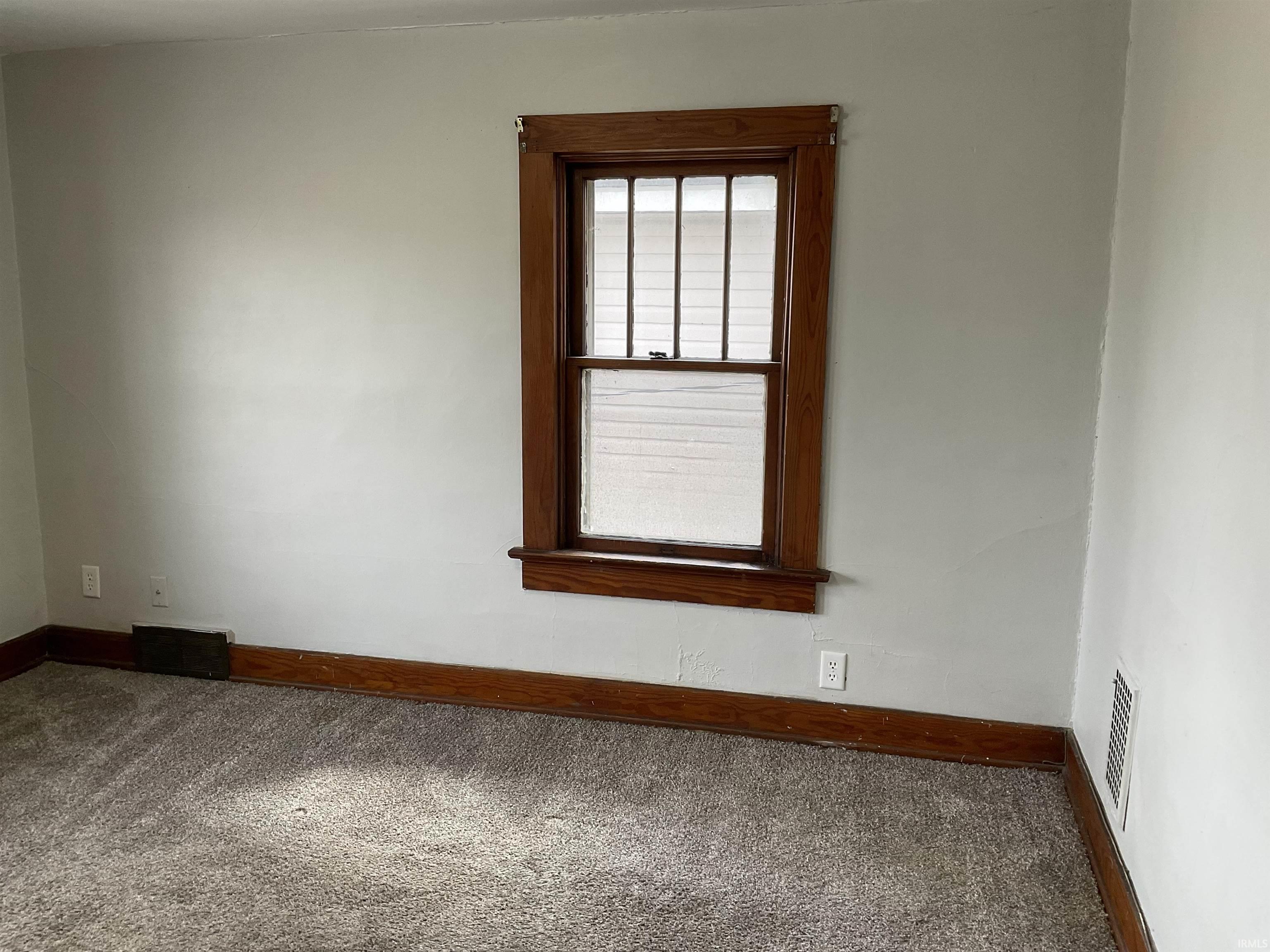 Carpeted spare room with baseboards