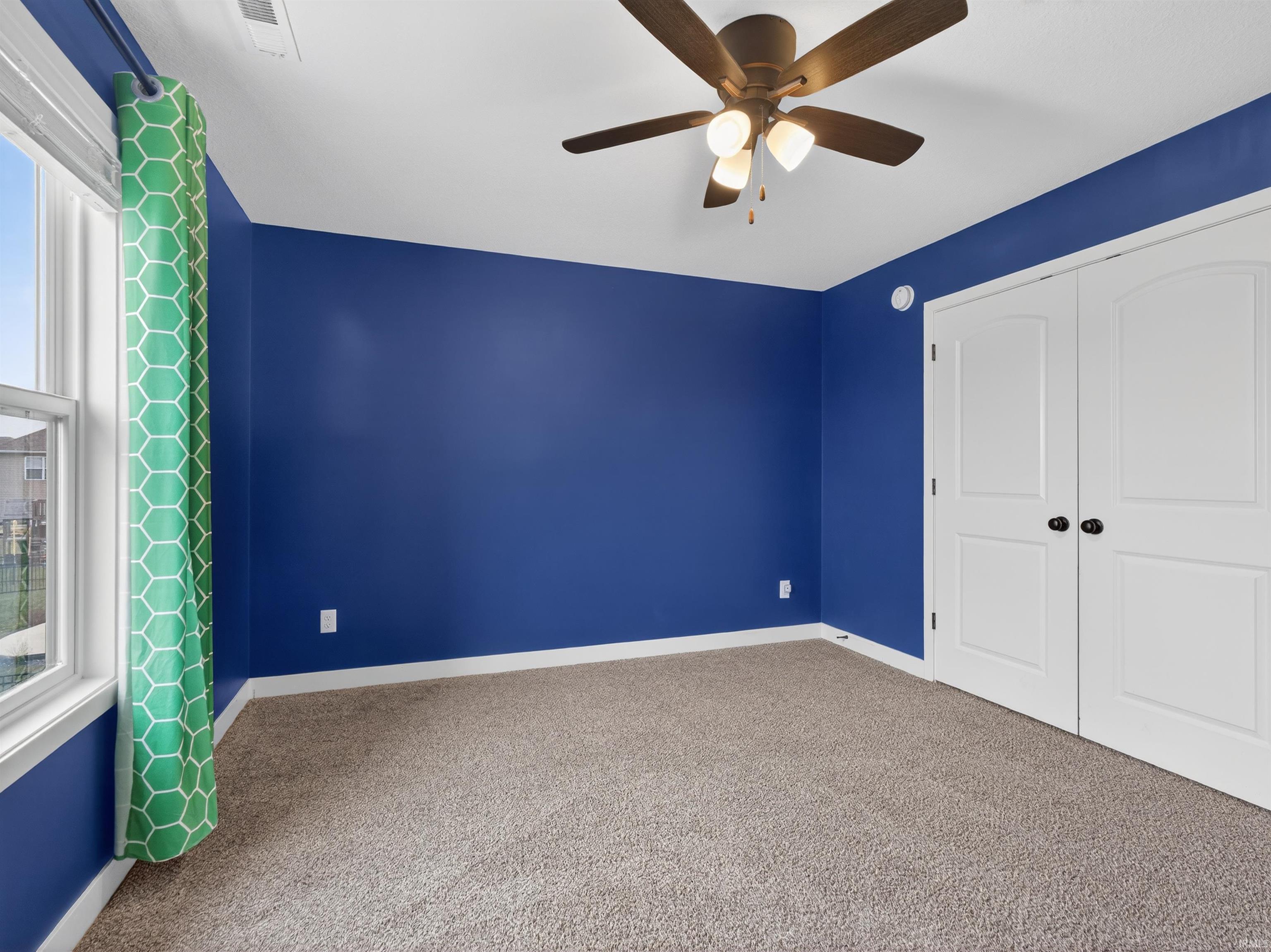 Unfurnished bedroom with carpet flooring, ceiling fan, and a closet