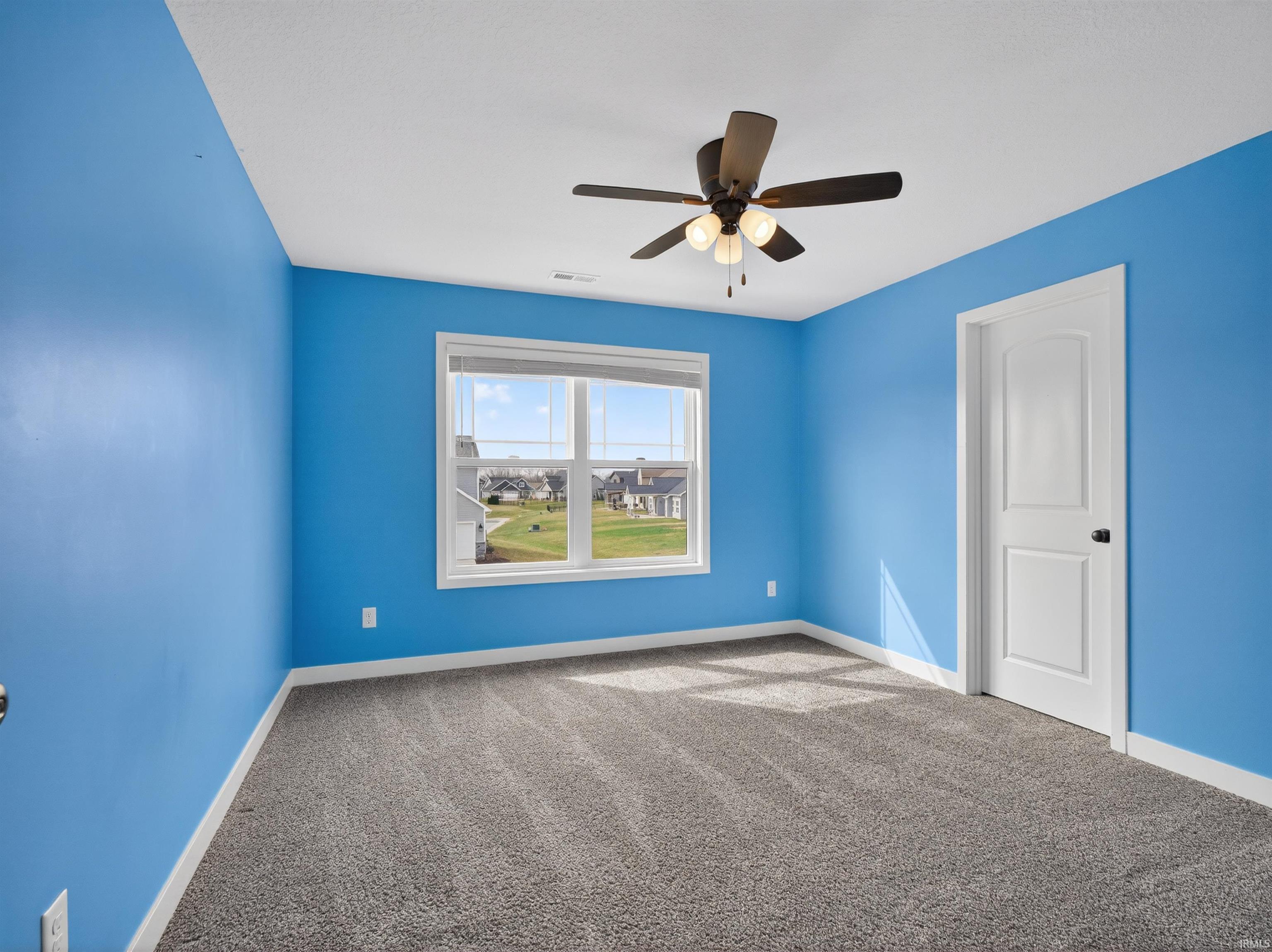 Unfurnished room featuring carpet and a ceiling fan