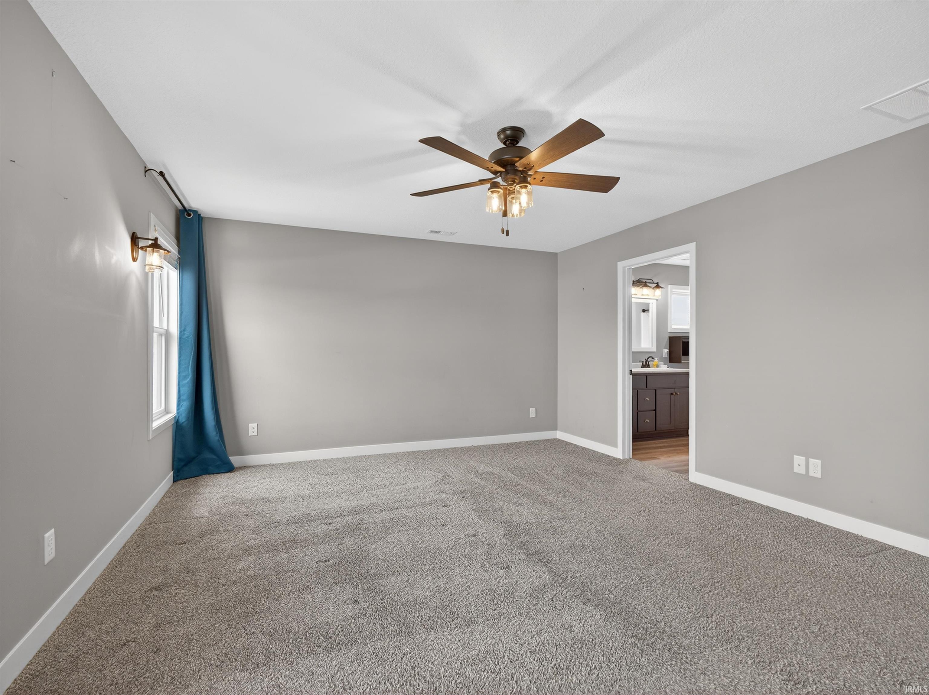 Spare room with light carpet and a ceiling fan