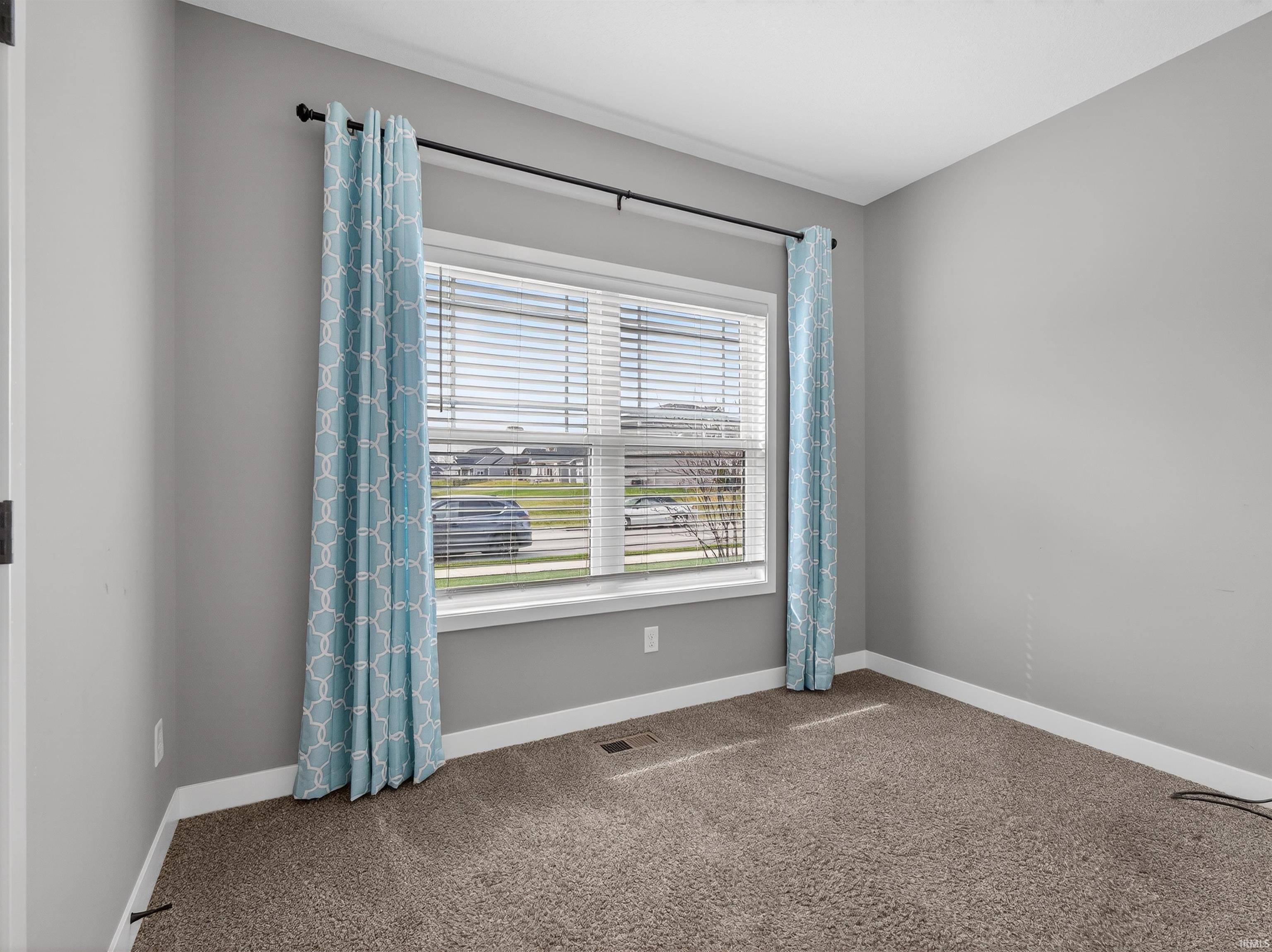 Unfurnished room featuring carpet and baseboards