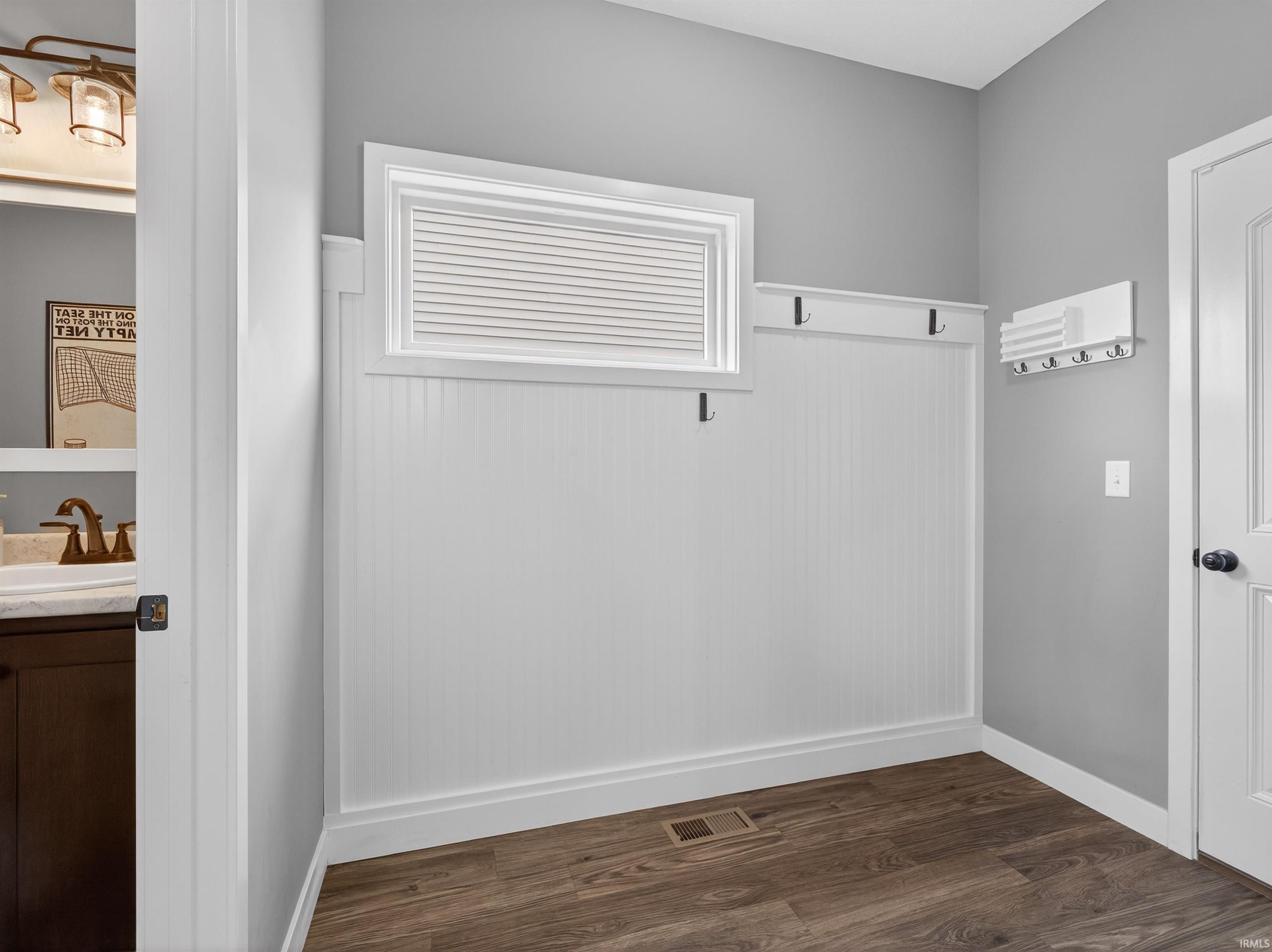 Mudroom featuring dark wood finished floors and baseboards