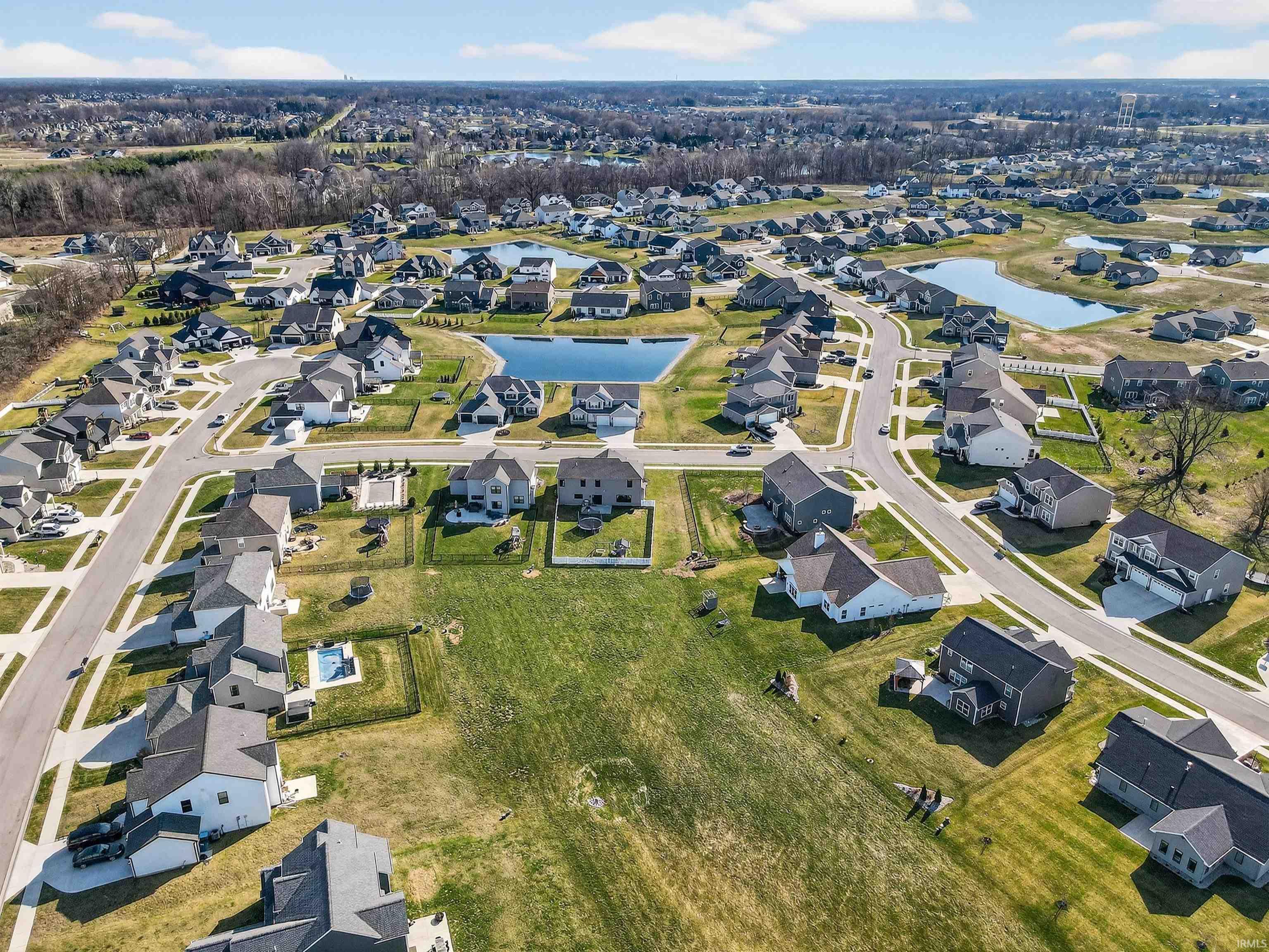 Aerial view of property's location with a nearby body of water and nearby suburban area