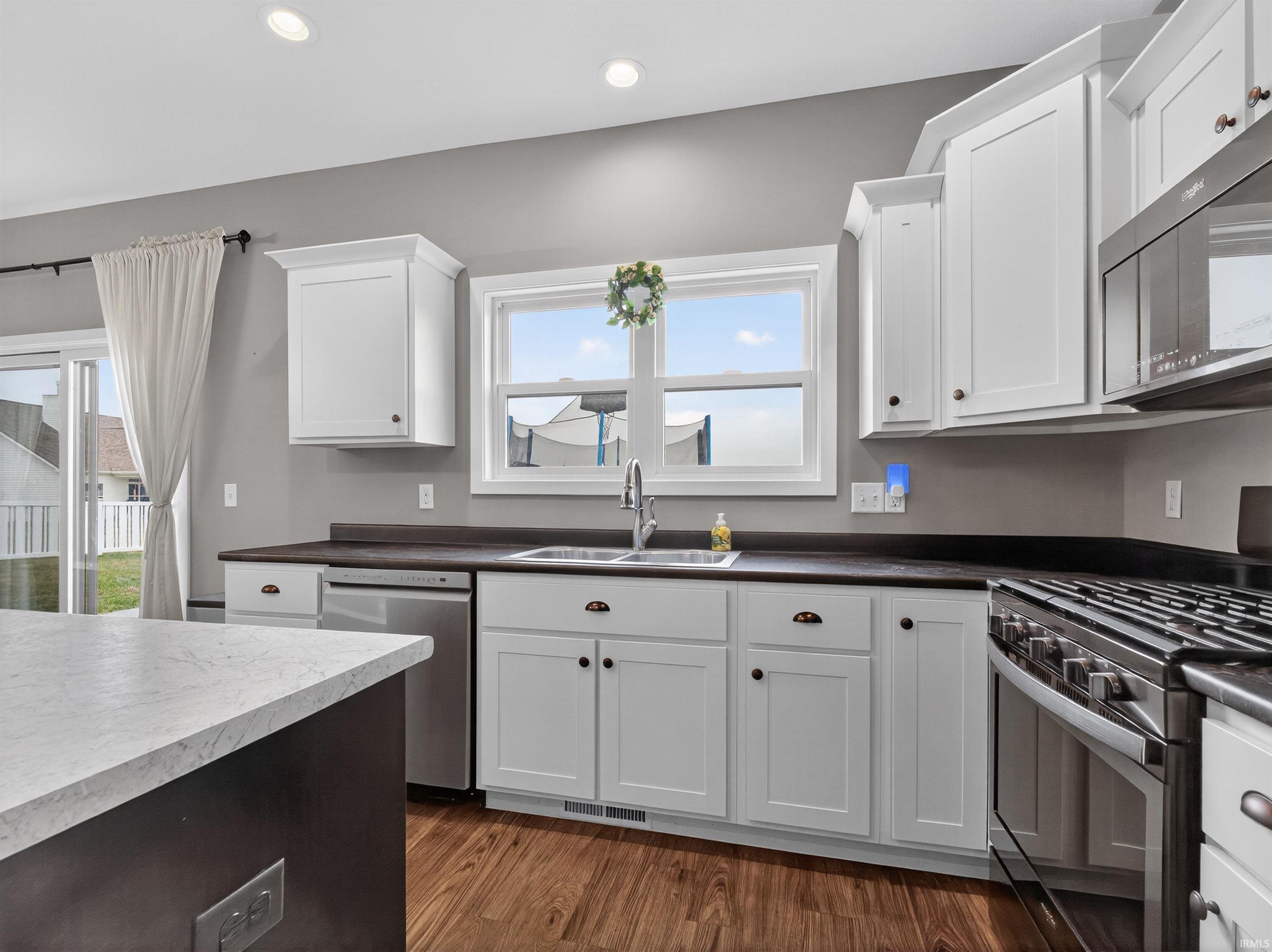 Kitchen featuring stainless steel appliances, plenty of natural light, white cabinetry, and recessed lighting