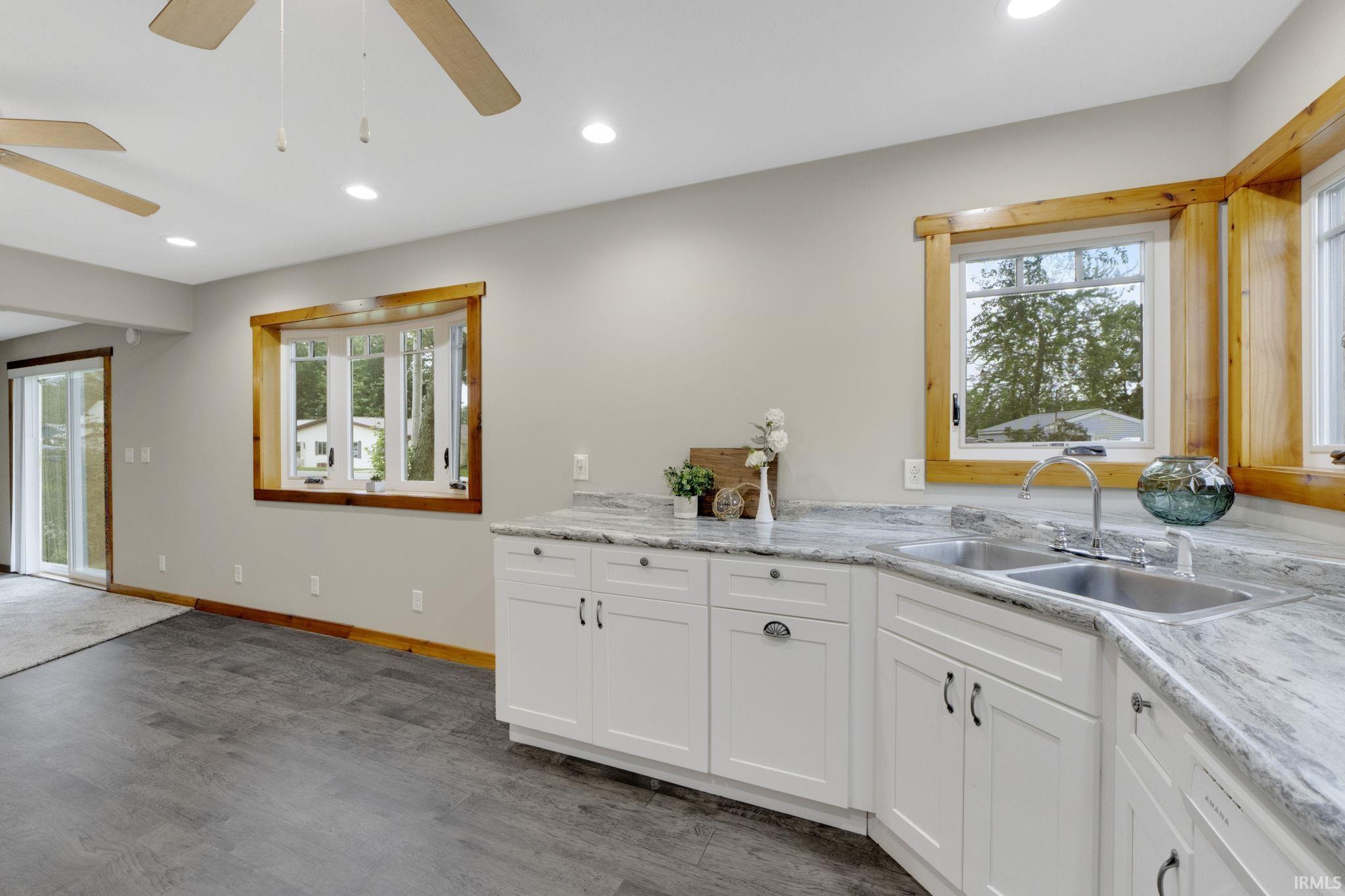 Kitchen with ceiling fan, white cabinetry, recessed lighting, and dark wood-style flooring