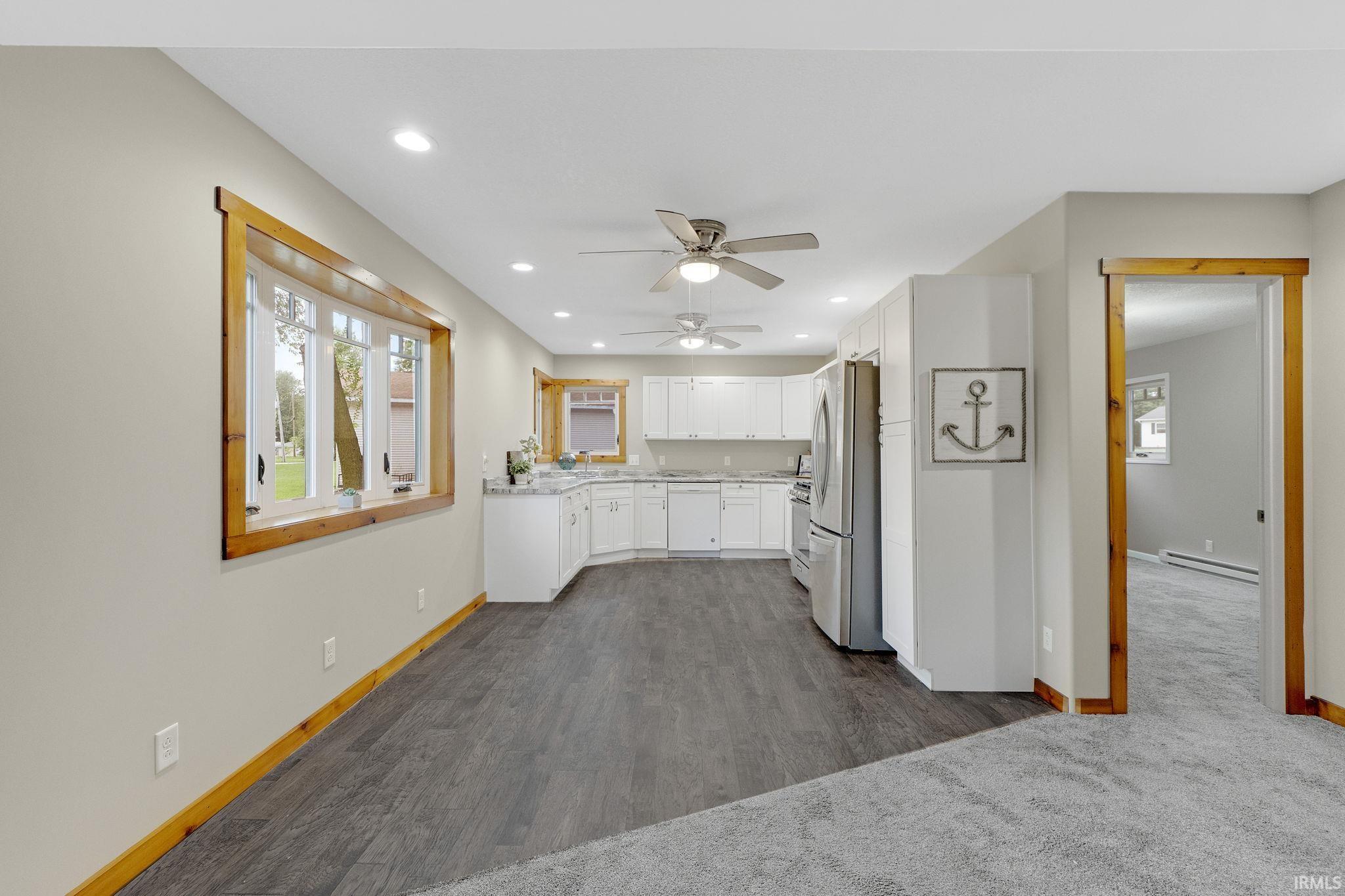 Kitchen with white cabinetry, recessed lighting, freestanding refrigerator, a ceiling fan, and dishwasher