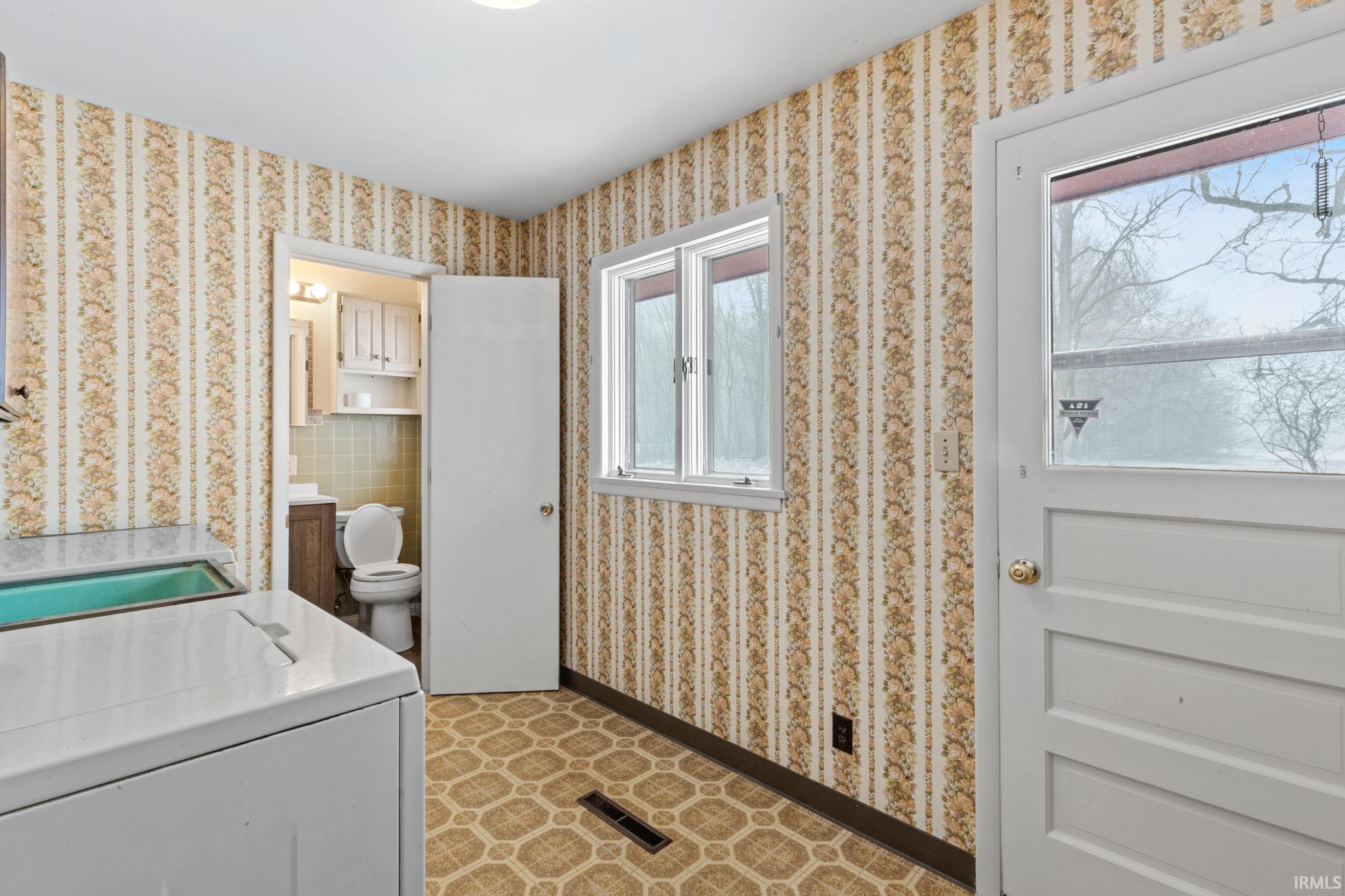 Laundry area with washer / dryer and wallpapered walls