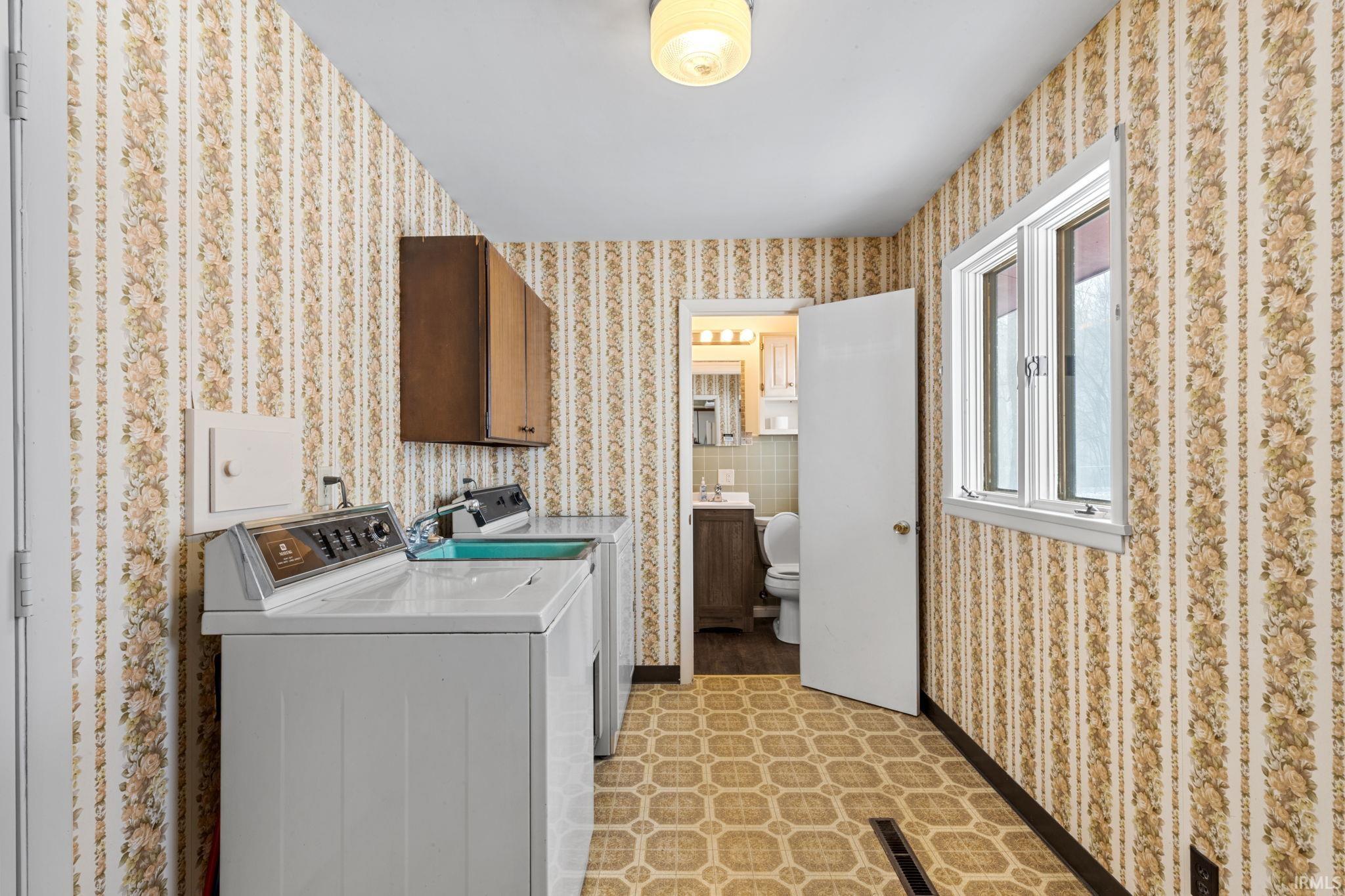 Laundry room with separate washer and dryer and cabinet space