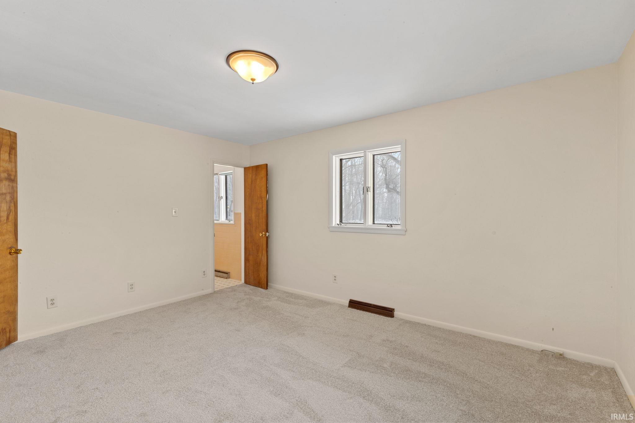 Unfurnished bedroom with carpet floors and baseboards