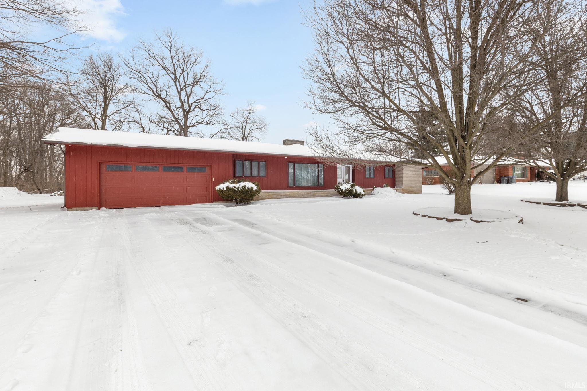 Ranch-style house featuring a chimney and an attached garage