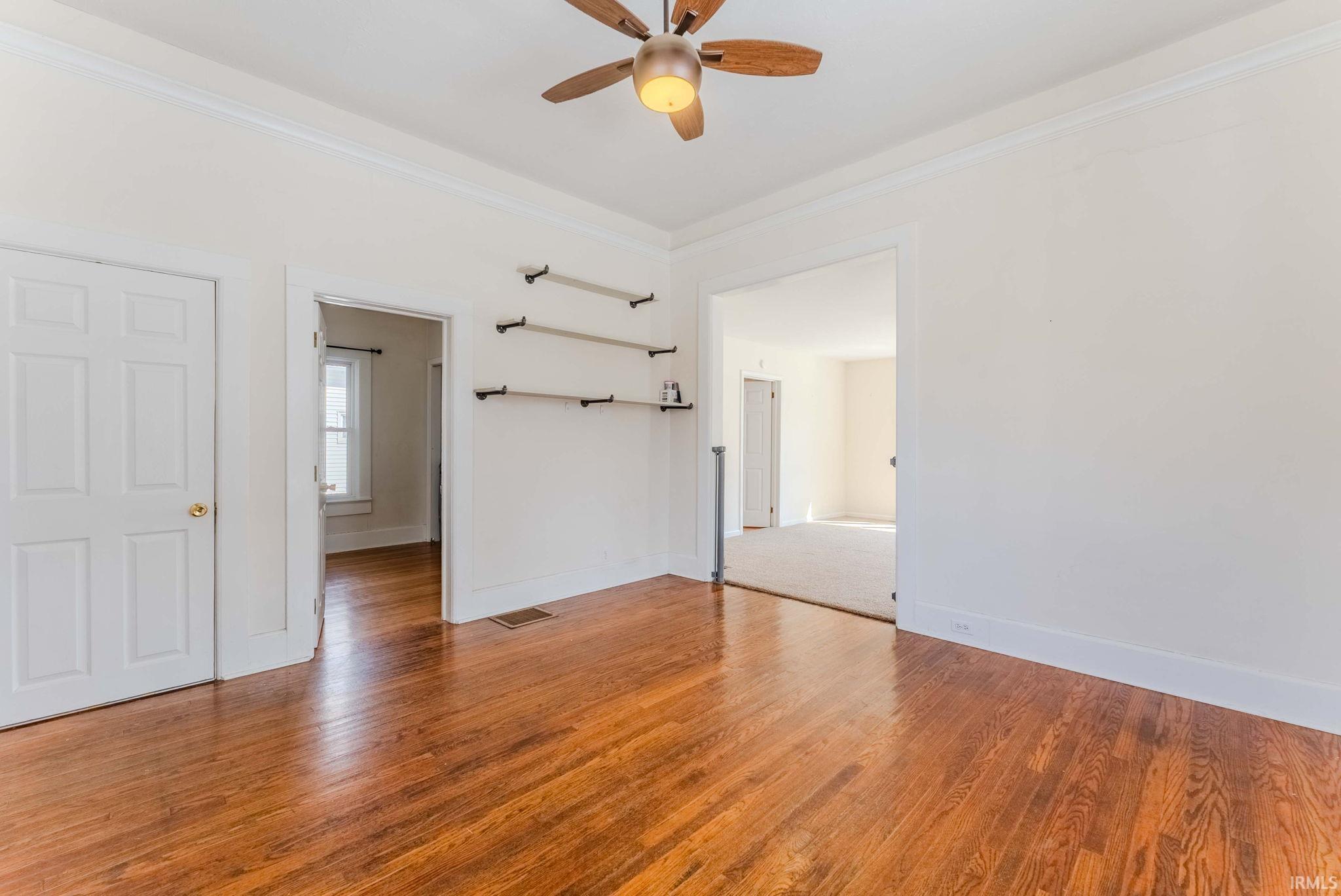 Dining room with ornamental molding, light wood-type flooring, and a ceiling fan