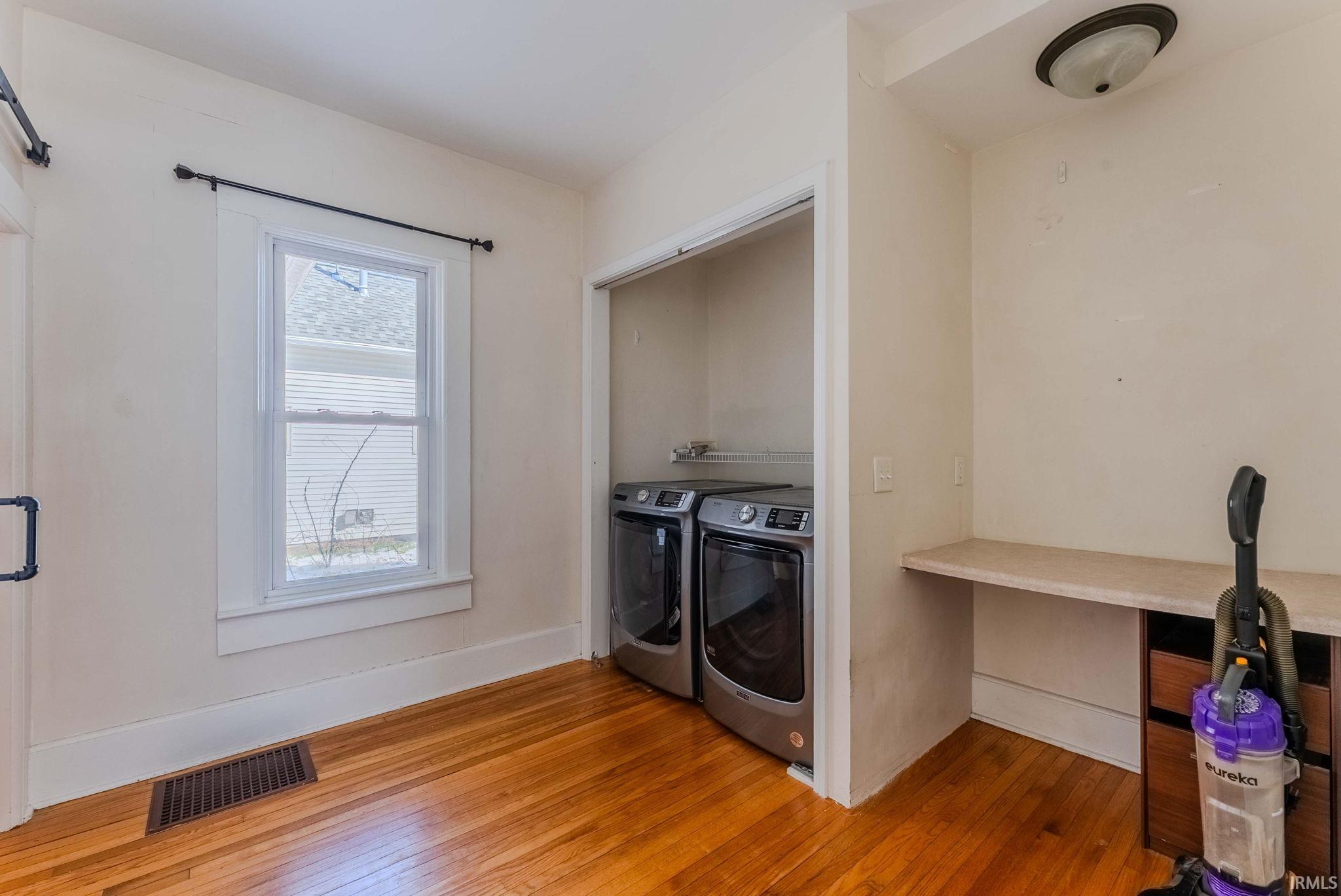 Laundry area with an office area, light wood-style flooring, and separate washer and dryer
