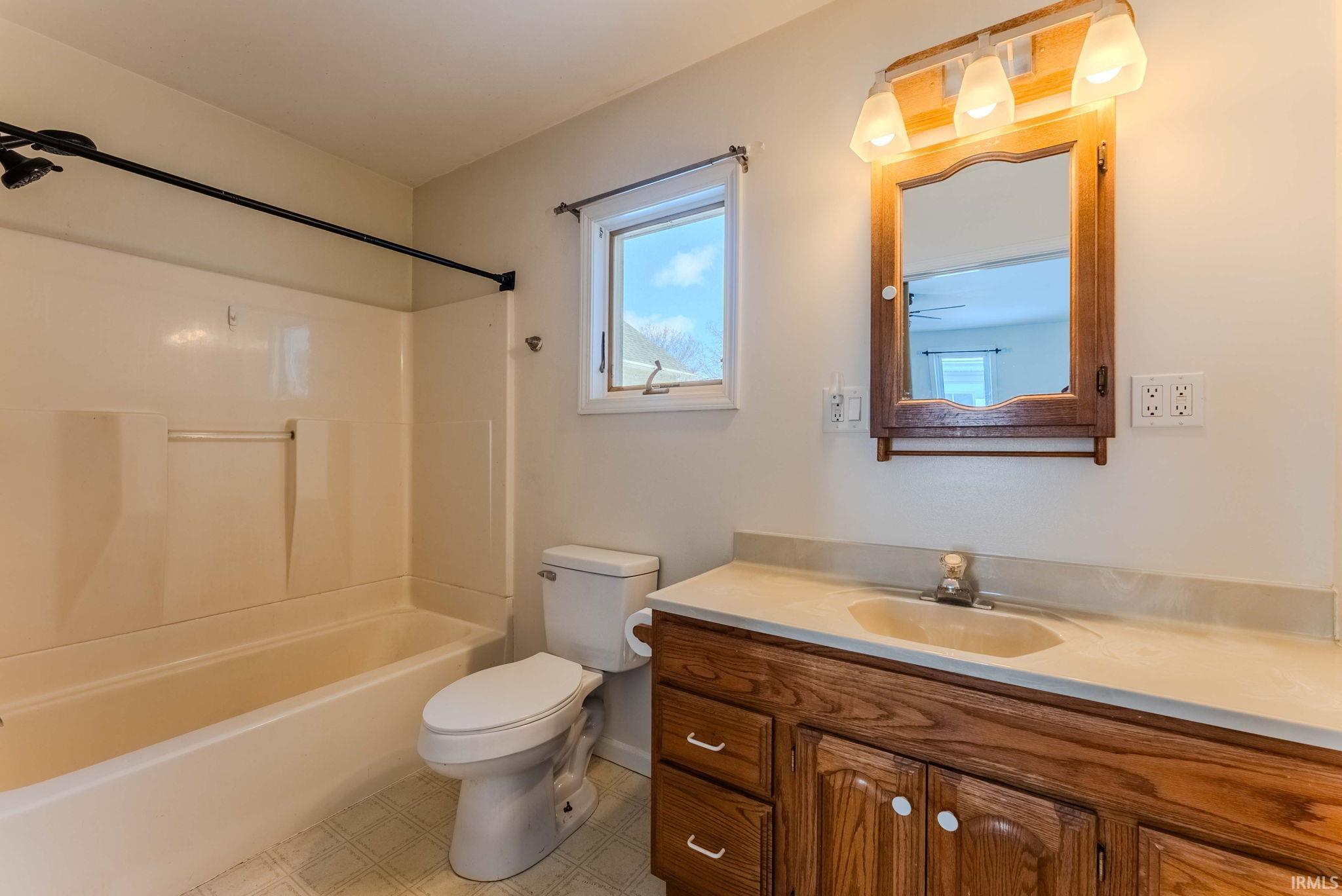 Full bathroom with vanity, bathing tub / shower combination, and light flooring