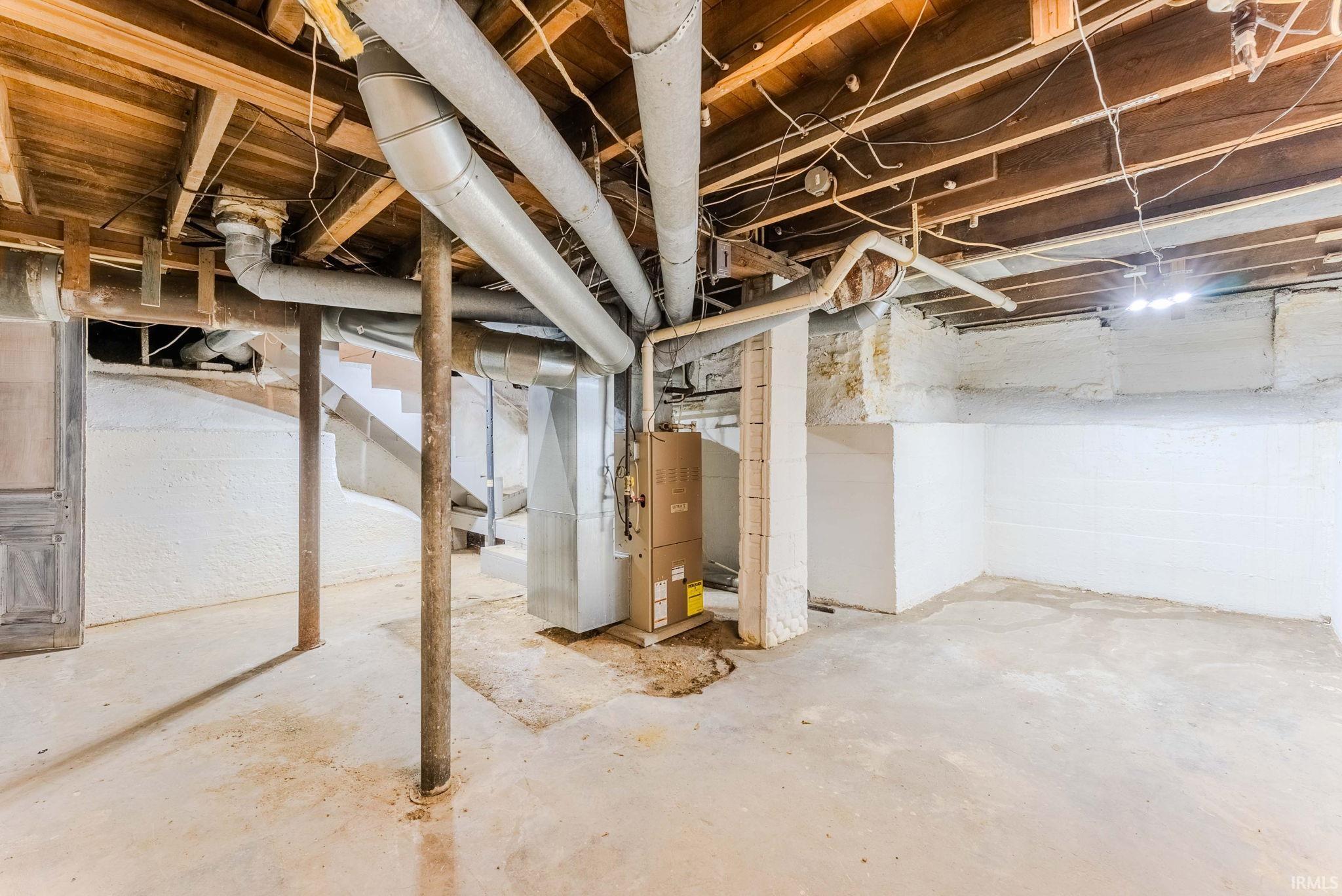 Unfinished below grade area featuring heating unit