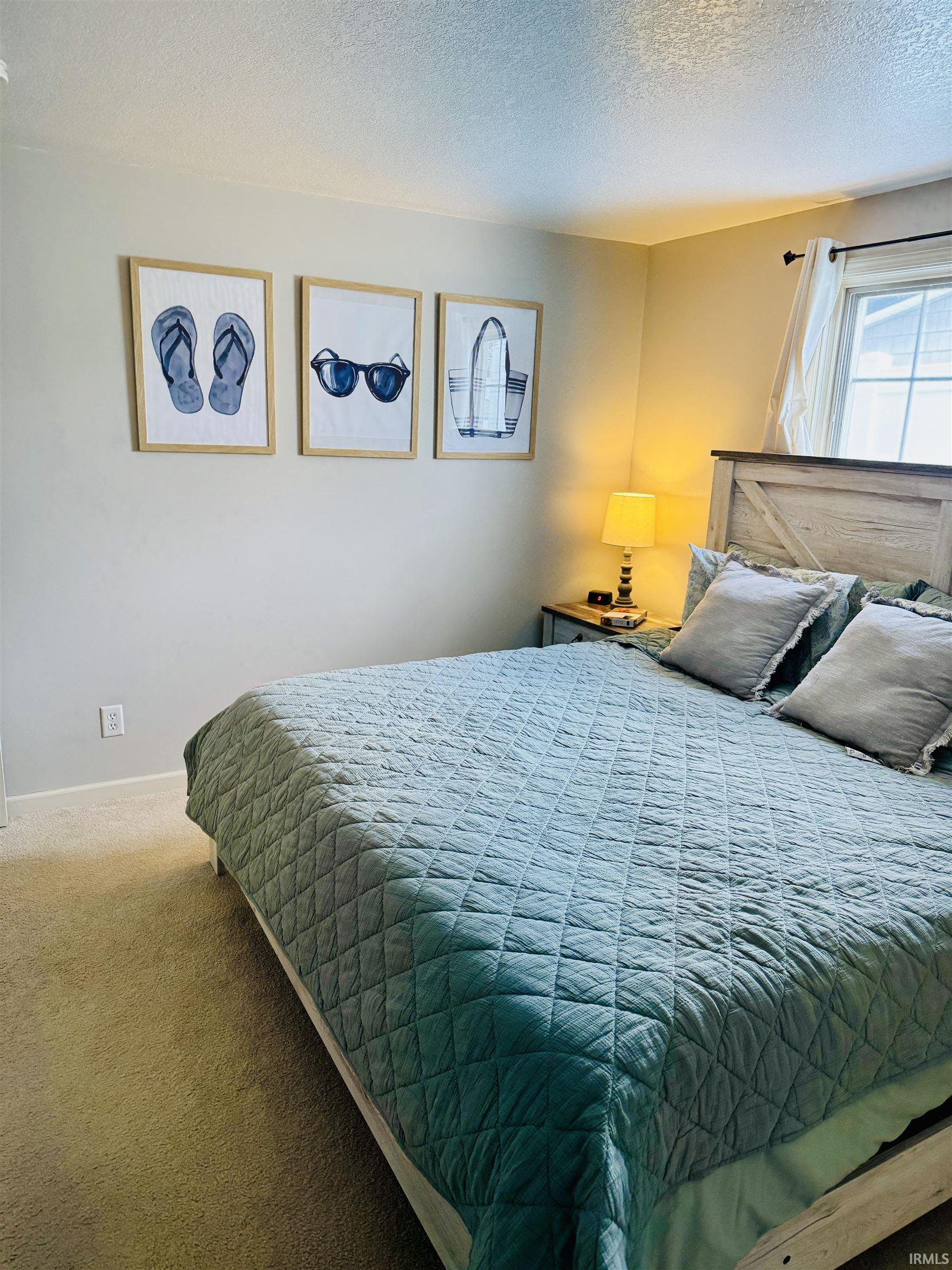 Bedroom featuring a textured ceiling and carpet