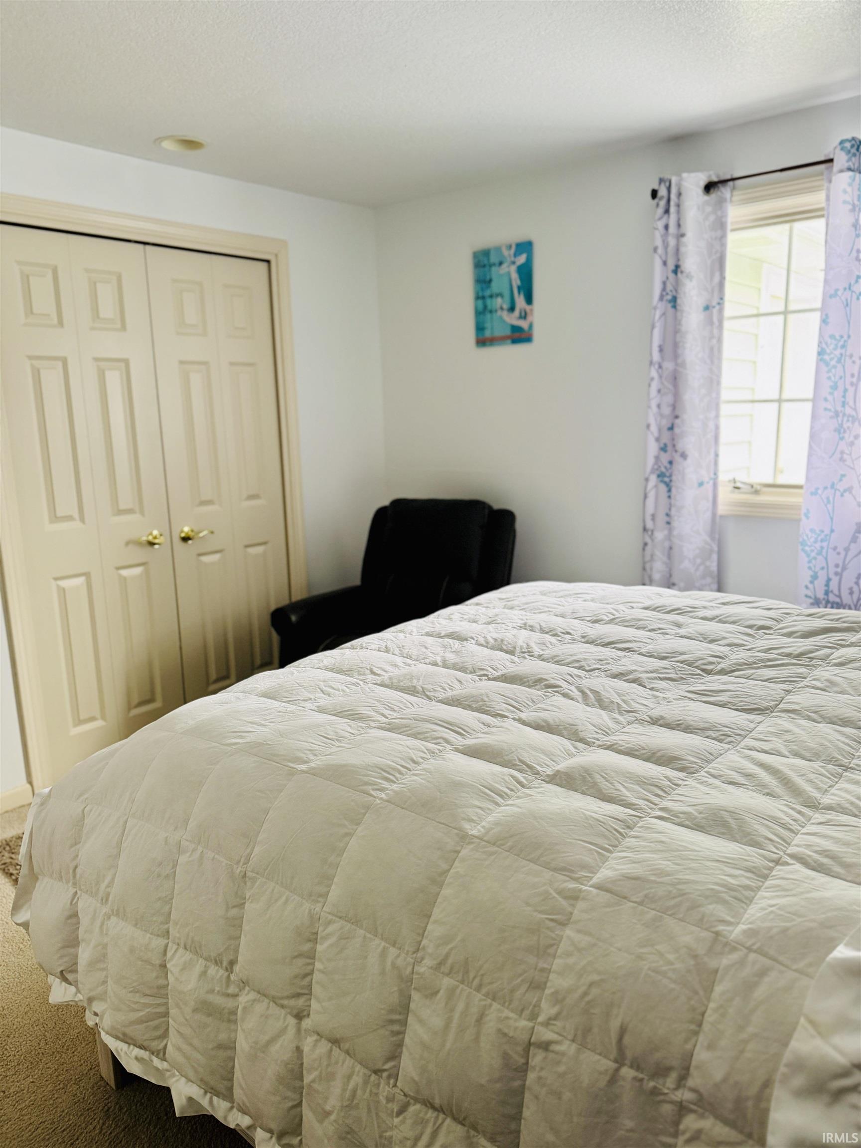 Carpeted bedroom with a closet and a textured ceiling