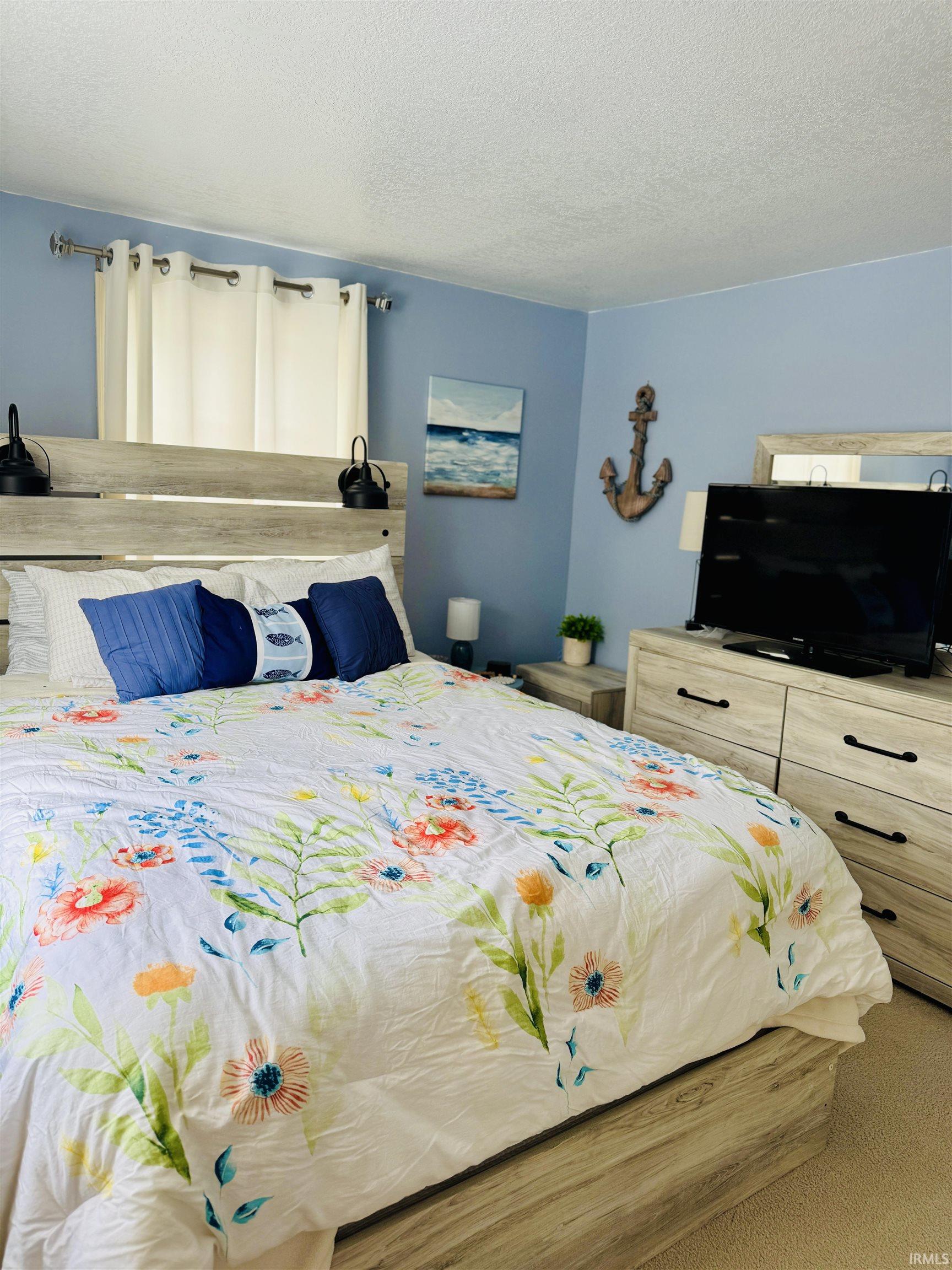 Carpeted bedroom with a textured ceiling