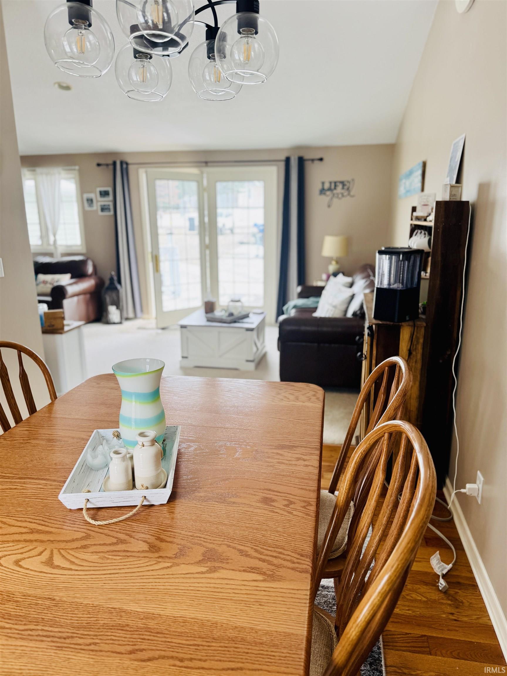 Dining space with wood finished floors and vaulted ceiling