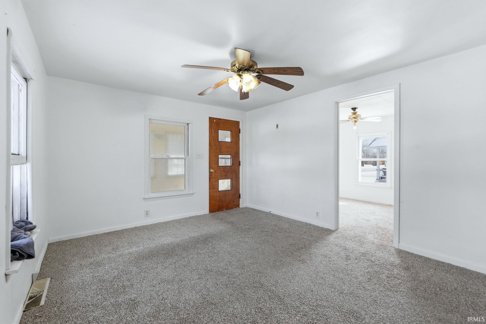 Unfurnished living room with carpet flooring and ceiling fan