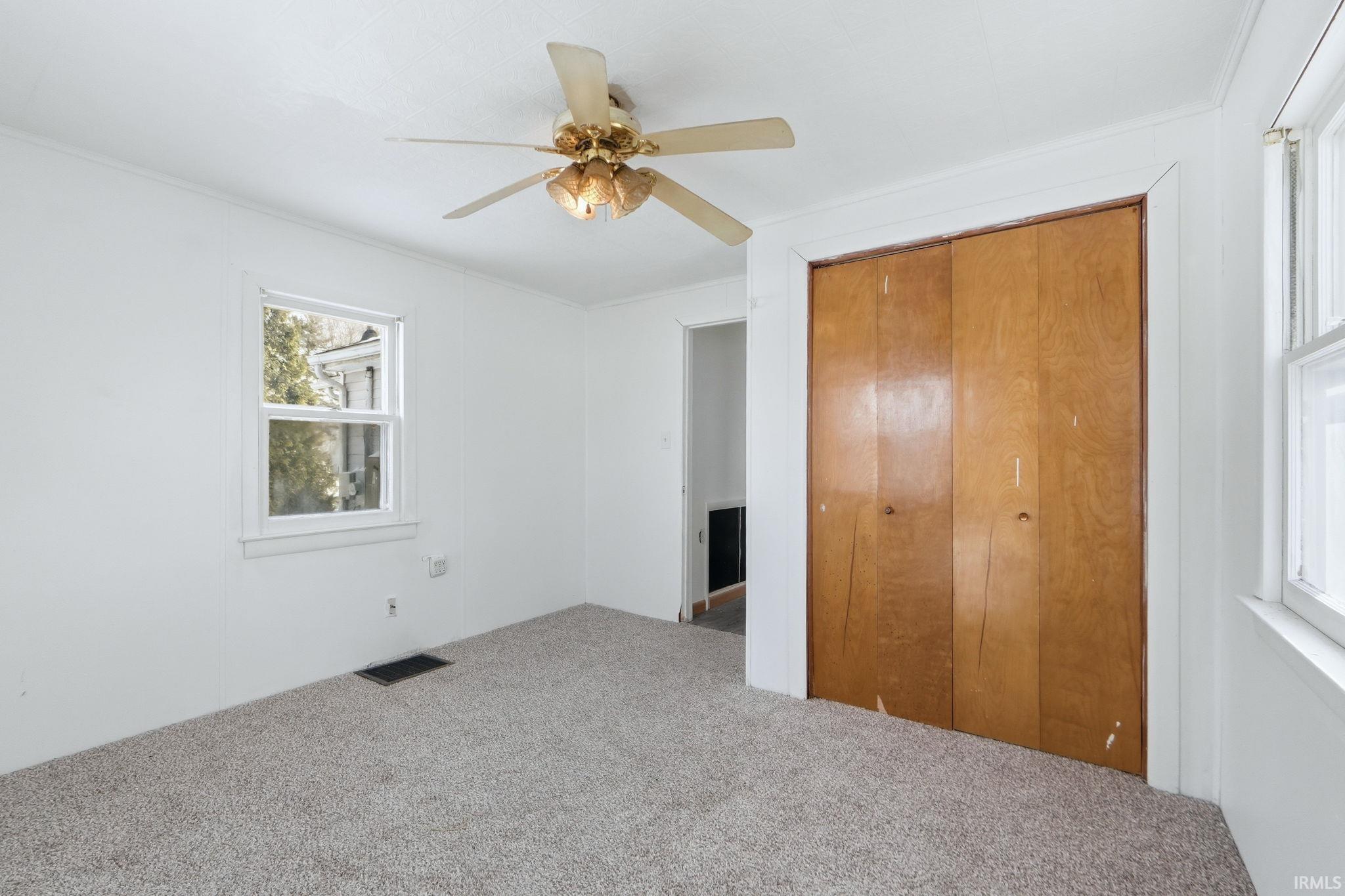 Unfurnished bedroom with a closet, carpet floors, and ceiling fan
