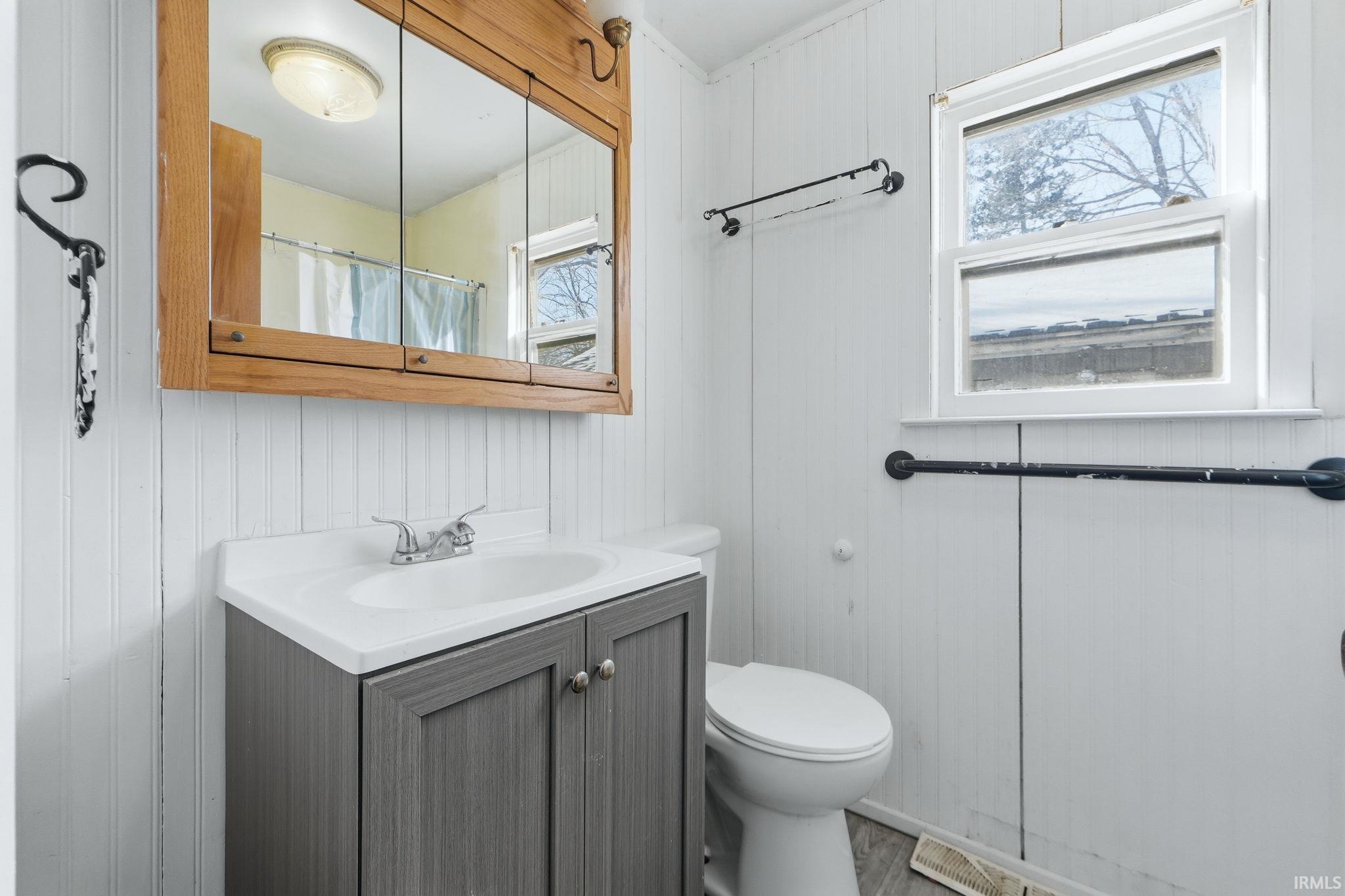 Full bathroom featuring vanity, a shower with shower curtain, and wood finished floors