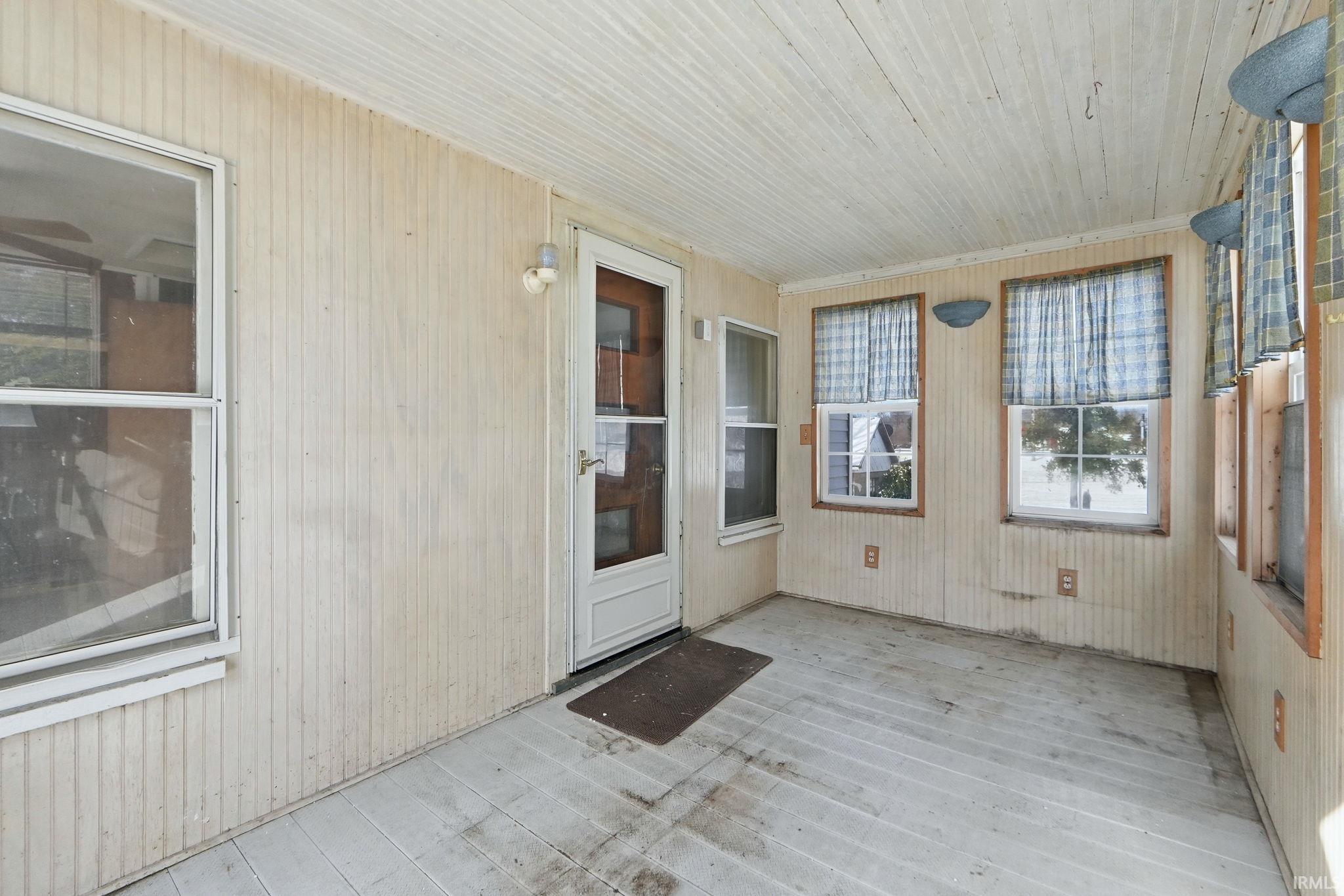 Property entrance featuring a sunroom