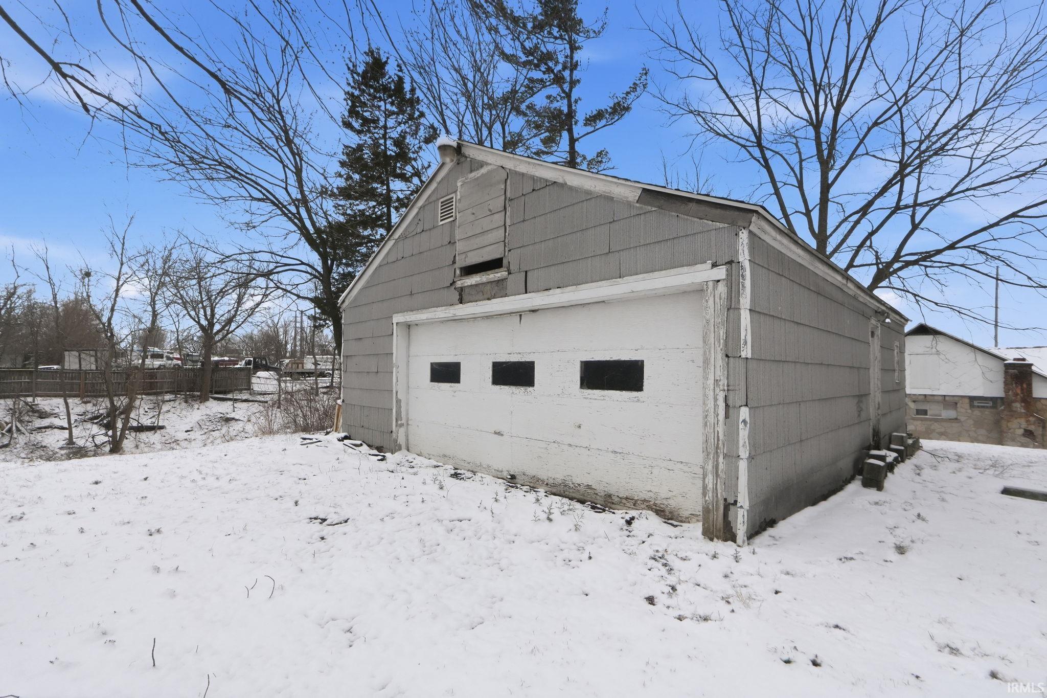 Snow covered garage with a garage