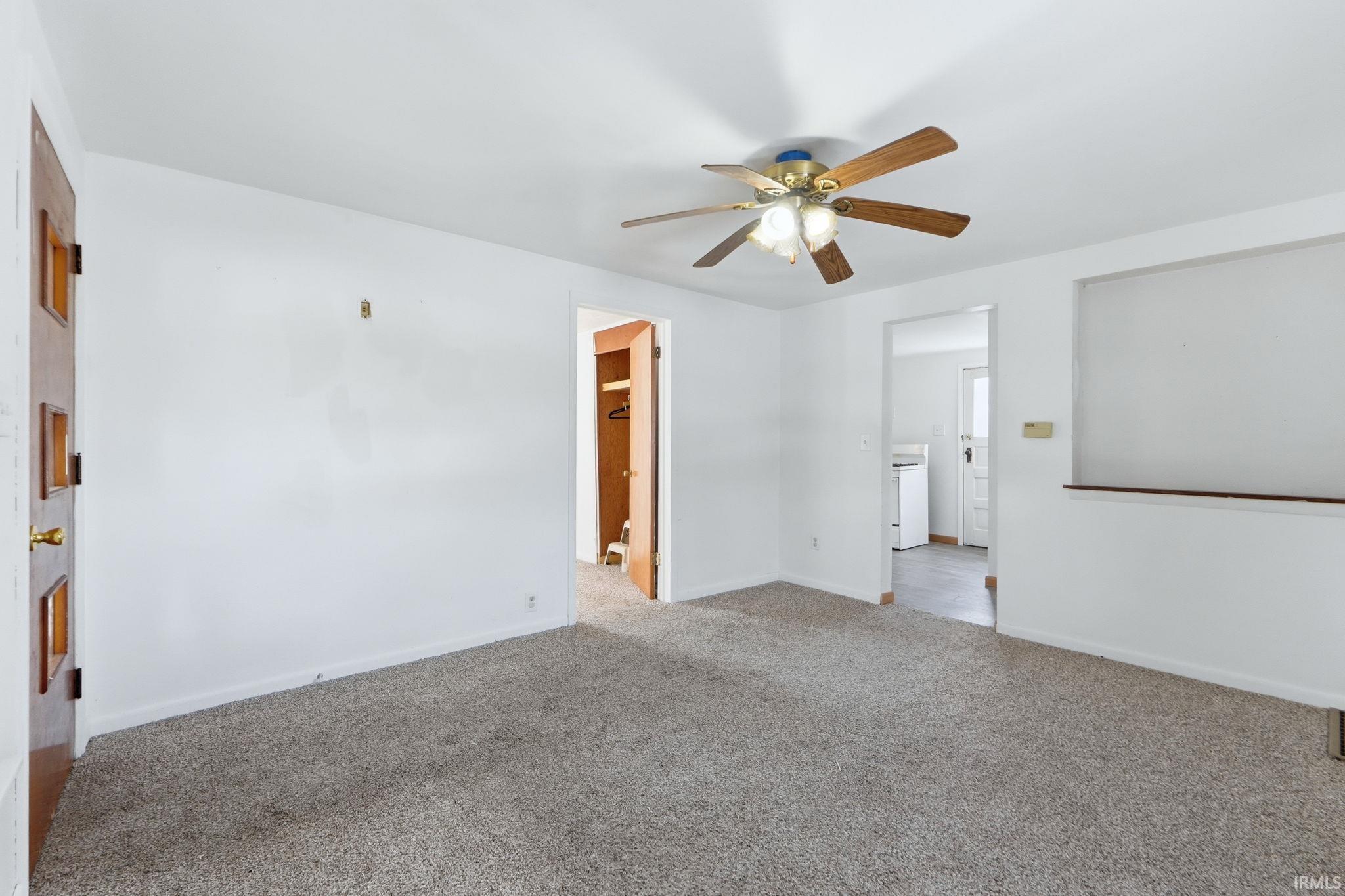 Spare room featuring ceiling fan and light colored carpet