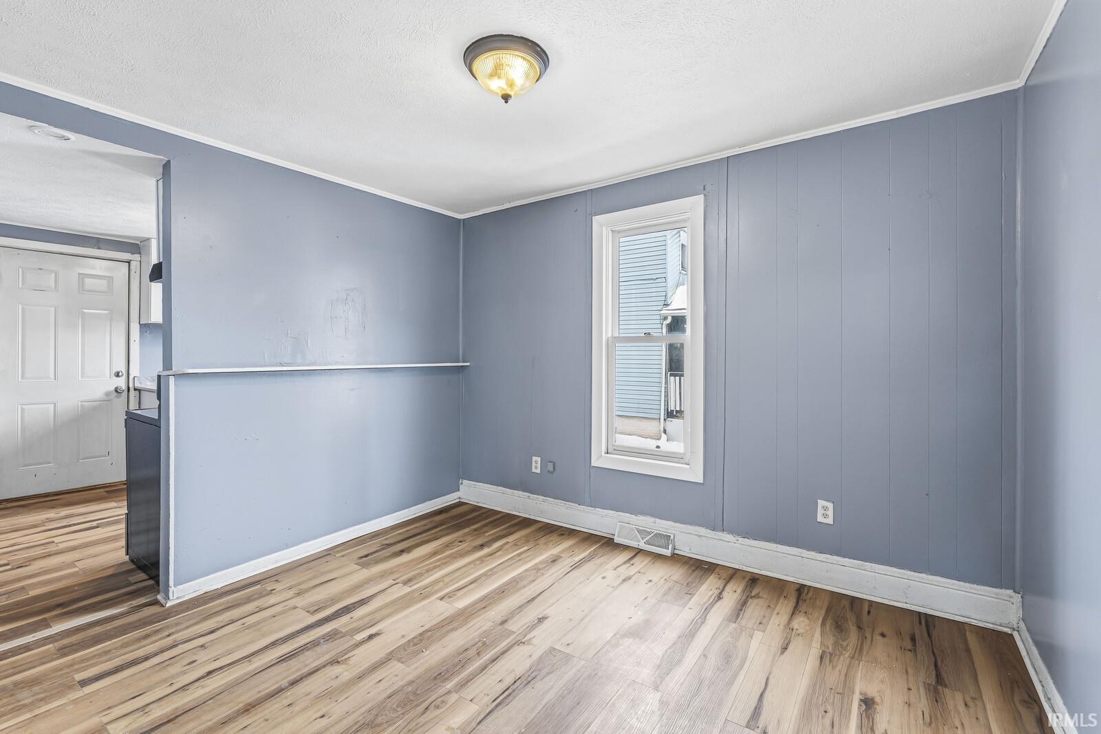 Spare room with light wood-style floors and ornamental molding