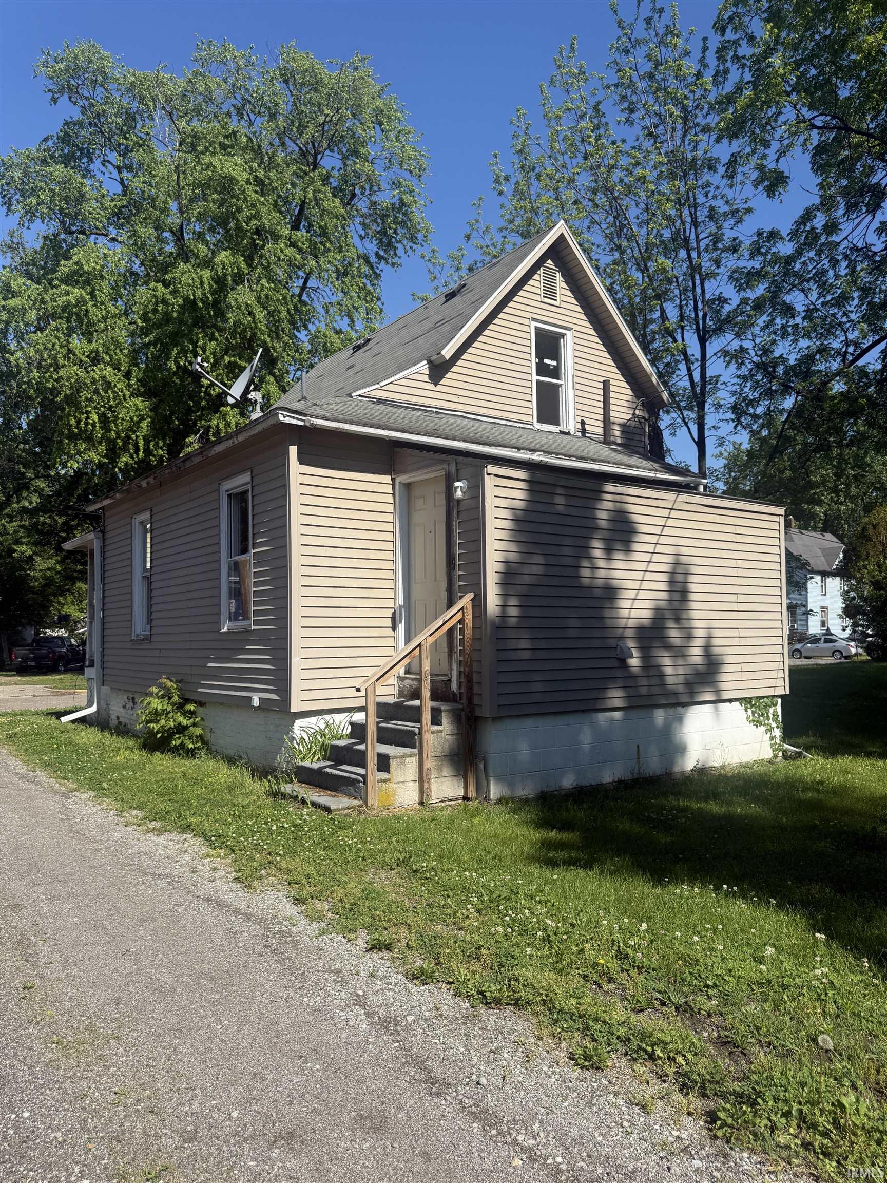 Two-story home with light-colored horizontal siding and a dark shingle roof