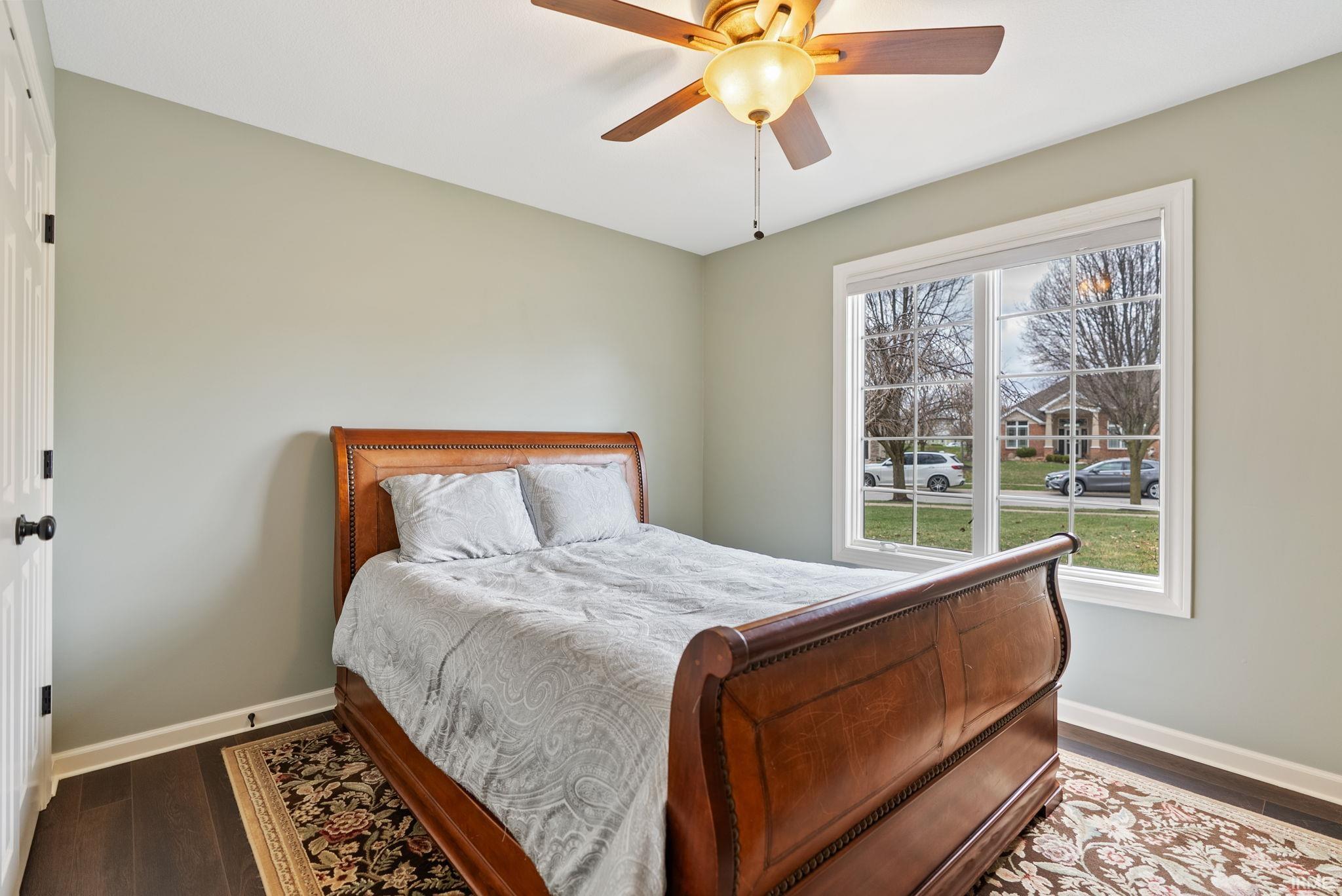 Bedroom with a closet, dark wood-style floors, and a ceiling fan