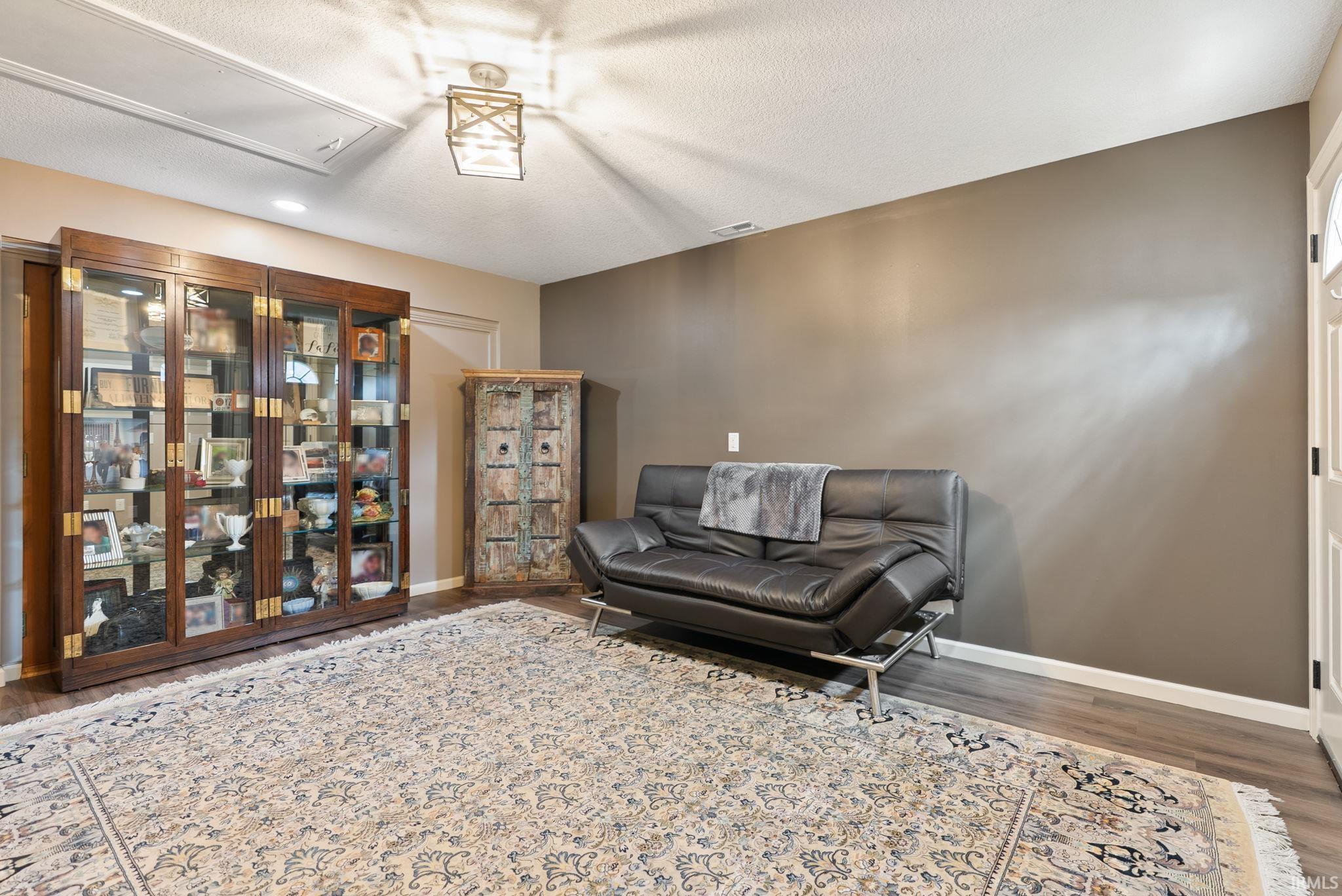 Sitting room with wood finished floors, a textured ceiling, and recessed lighting